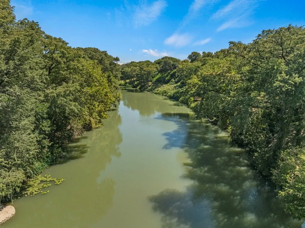 Riverfront setting with mature trees and expansive water feature