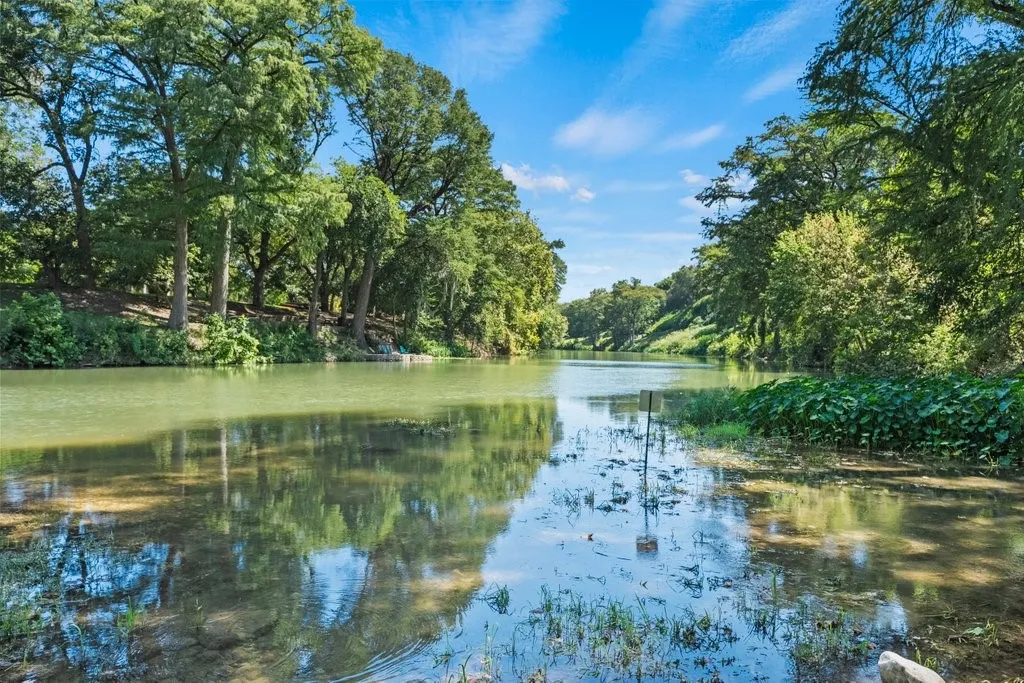 Natural waterway with lush, abundant trees framing both banks