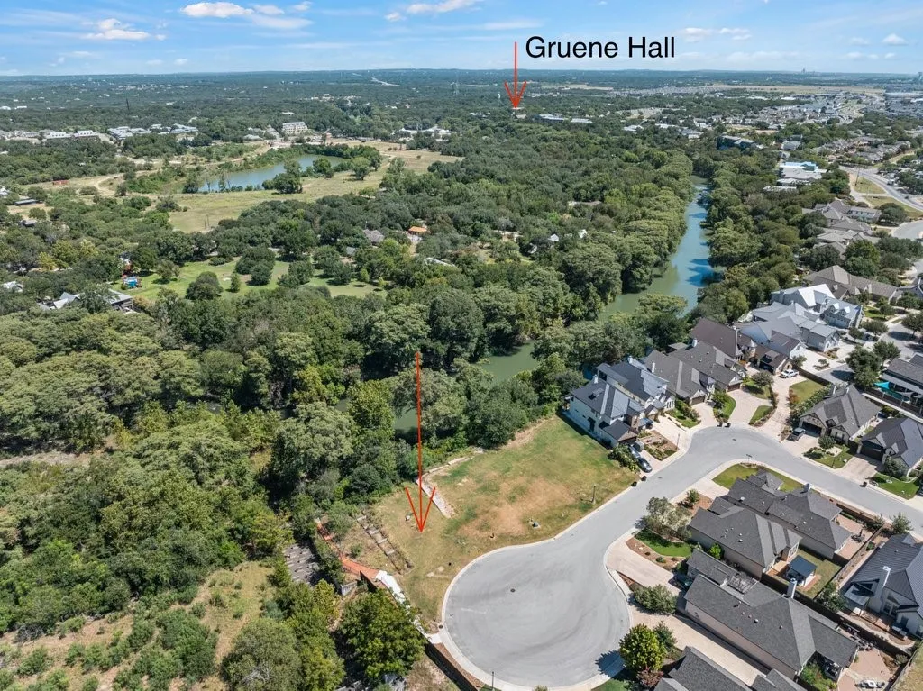 Expansive land parcel featuring a cul-de-sac location, bordering a natural waterway, and surrounded by mature trees