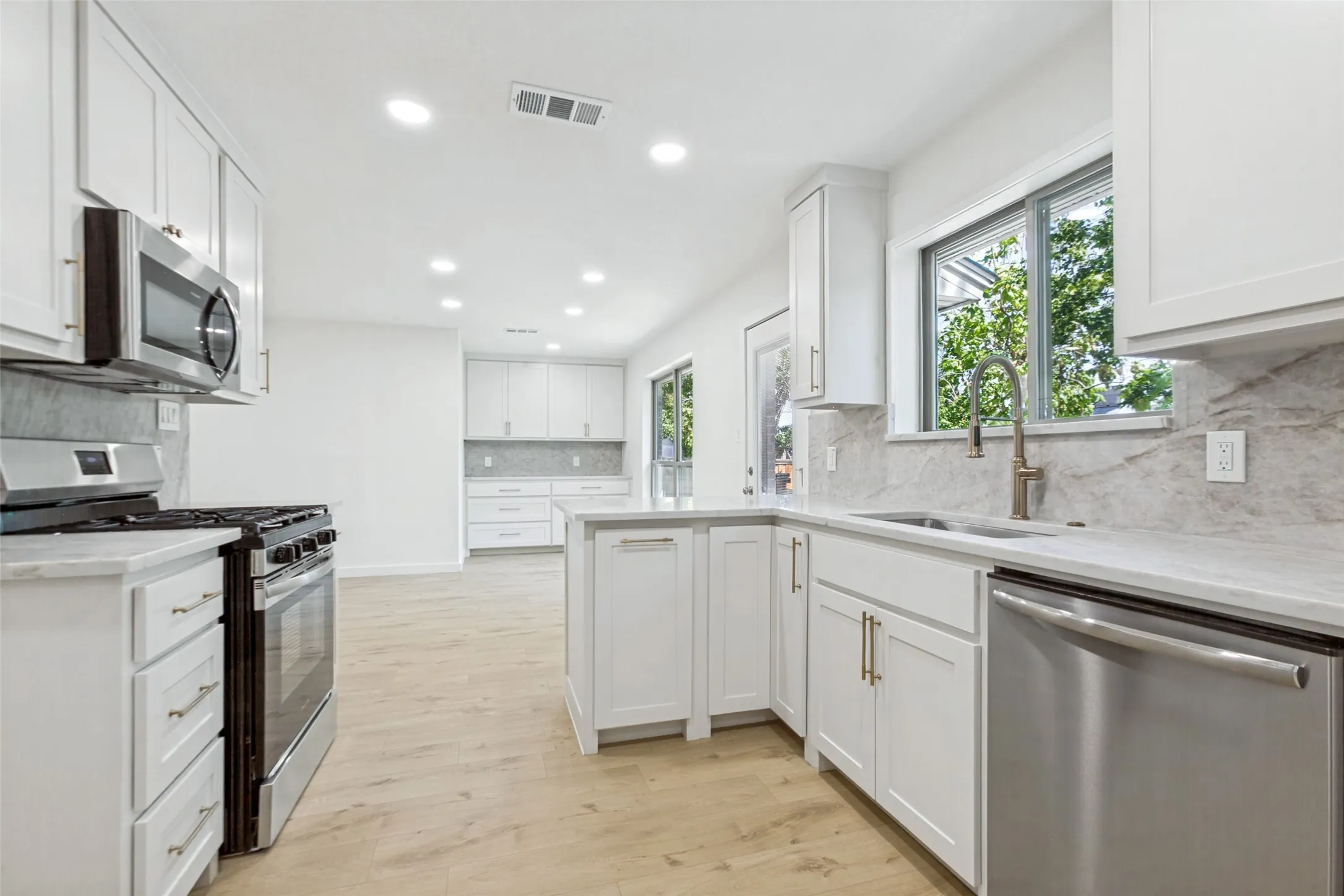 Kitchen features new gas range, pull-out trash, lazy Susan