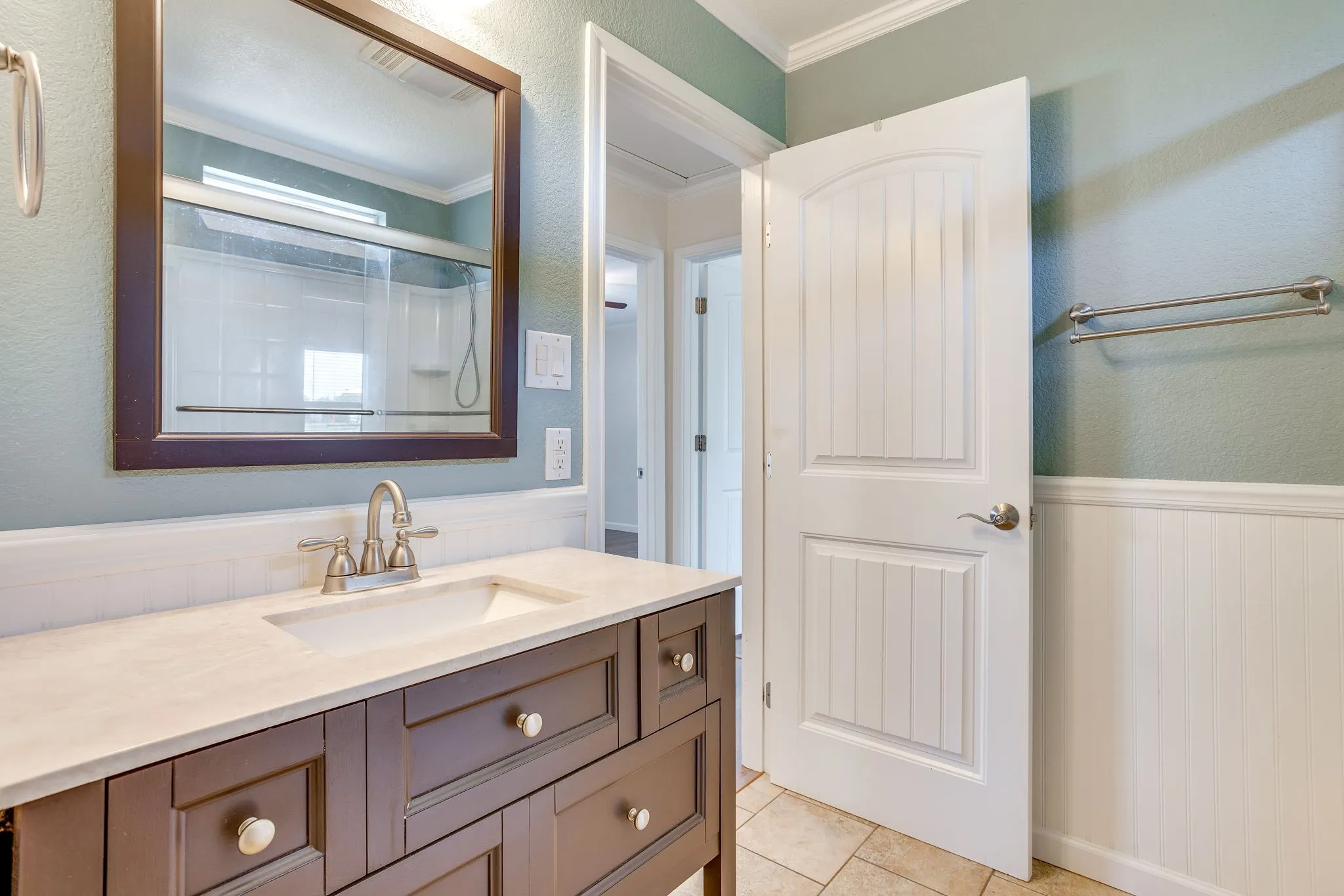 Dark wood-finish vanity with a light-toned countertop and an undermount sink