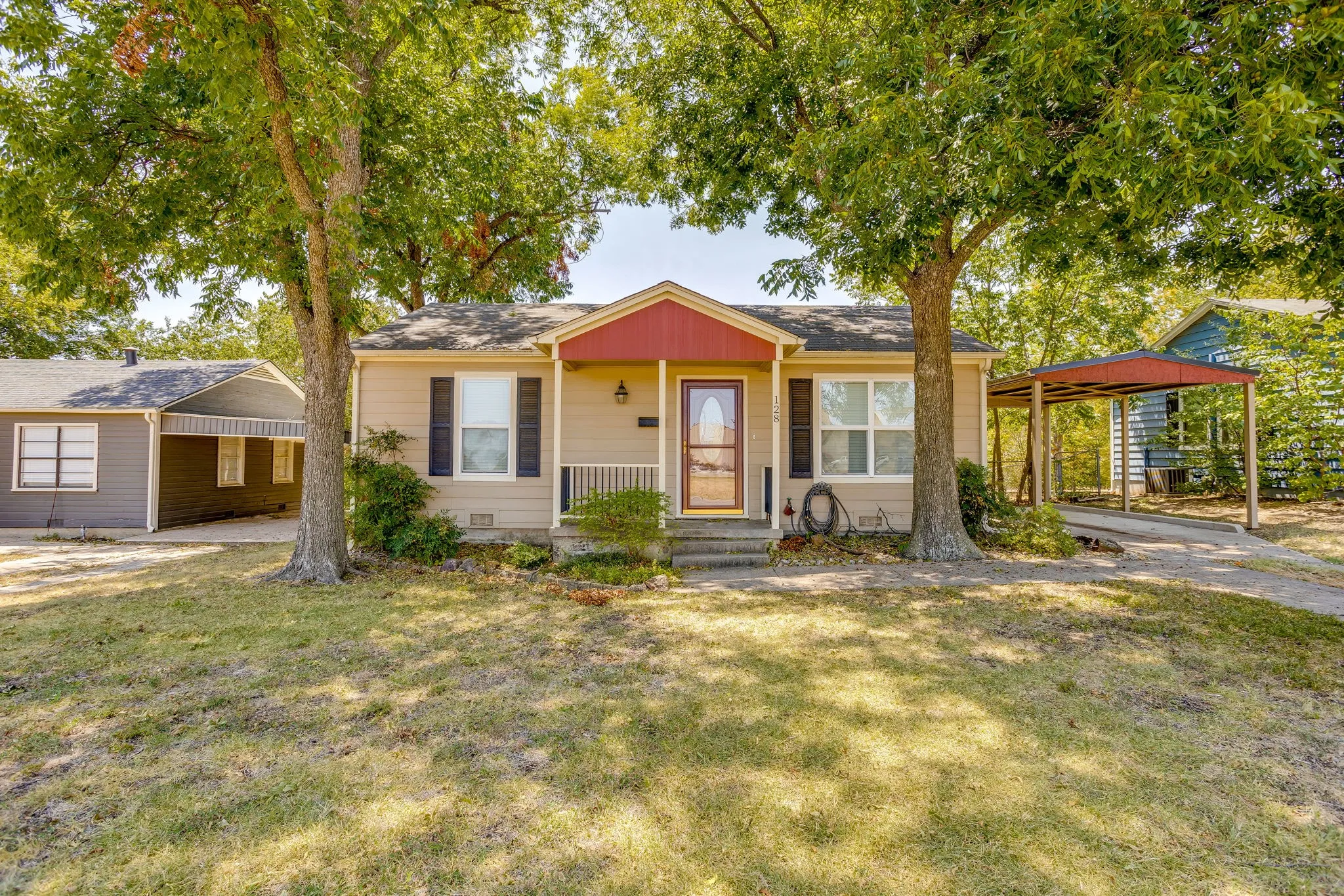 Single-story exterior with a covered porch, a storm door entry, and decorative window shutters