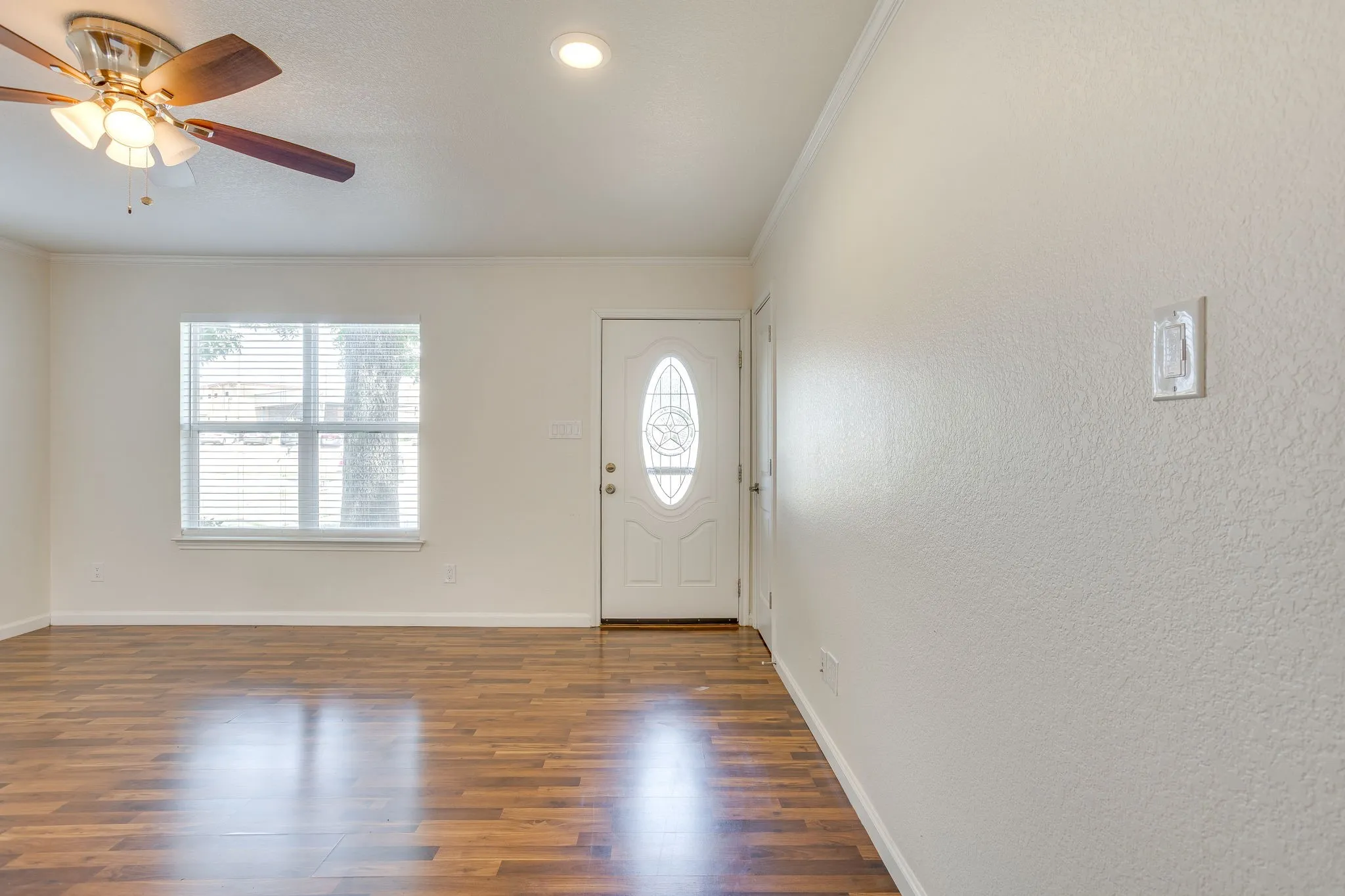 Laminate flooring with a ceiling fan, recessed lighting, and a window with blinds