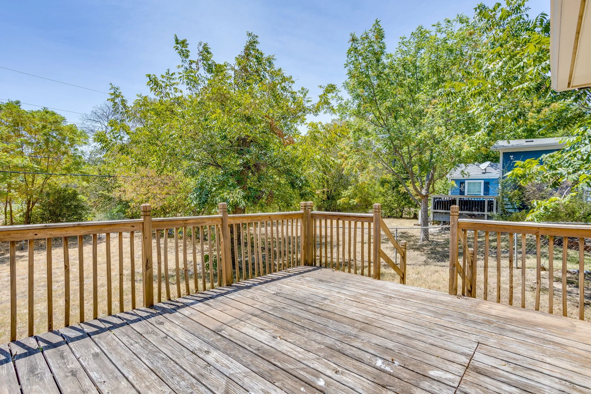 Spacious outdoor deck with natural wood railing and balusters