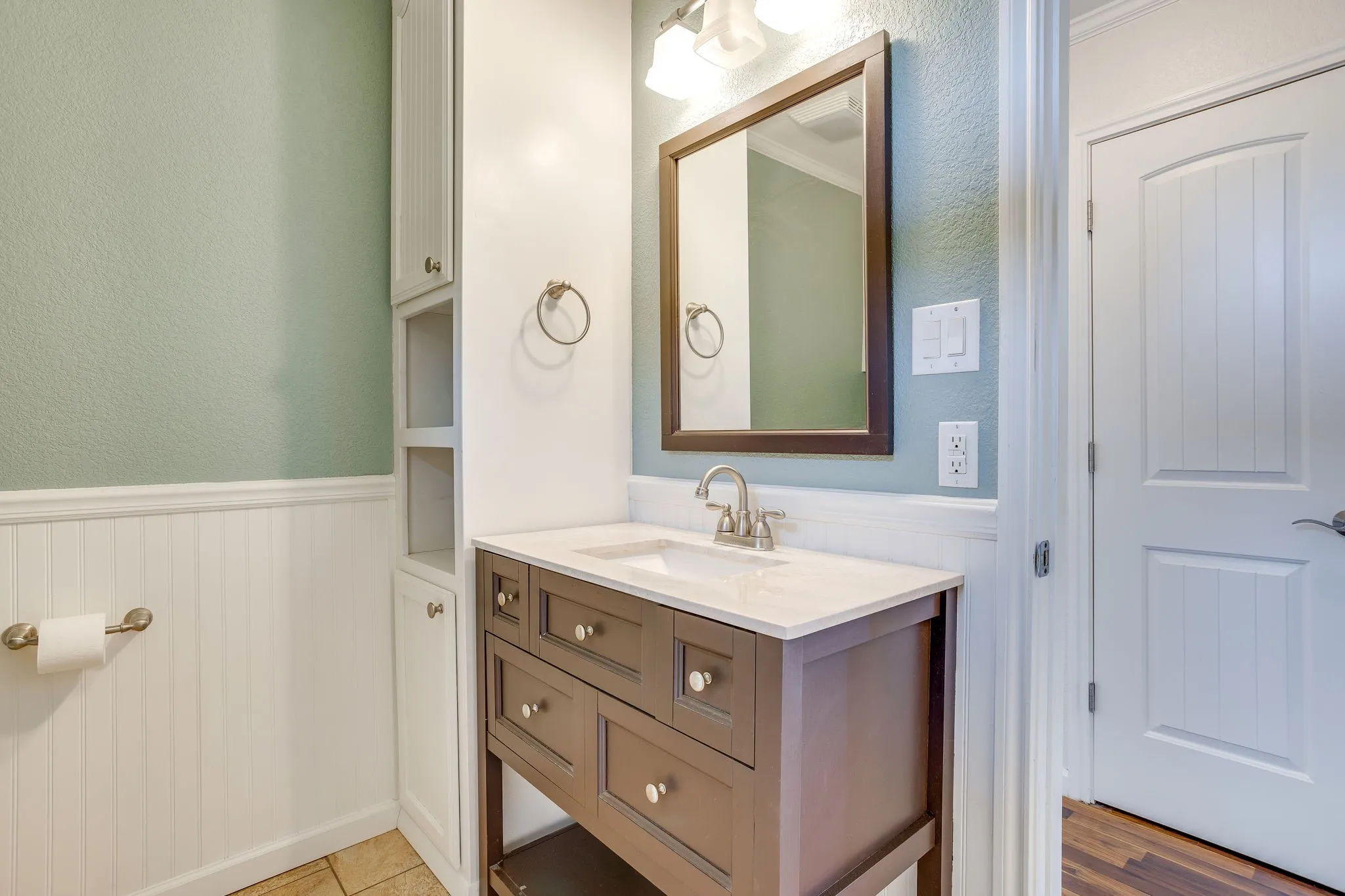 Vanity with a light-colored countertop, framed mirror, and chrome fixtures