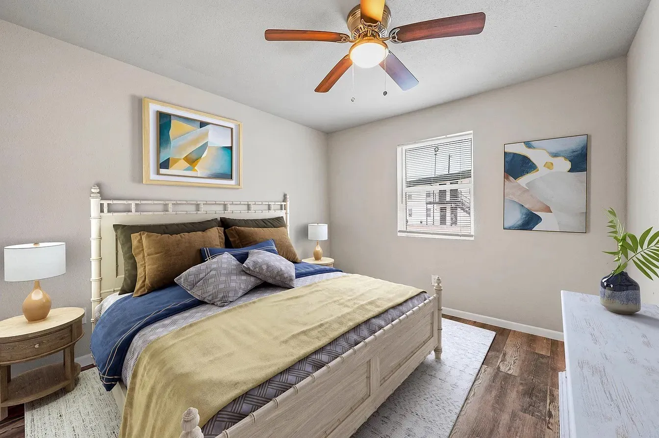 Wood-finish flooring, integrated ceiling fan with lighting, and multiple windows allowing natural light