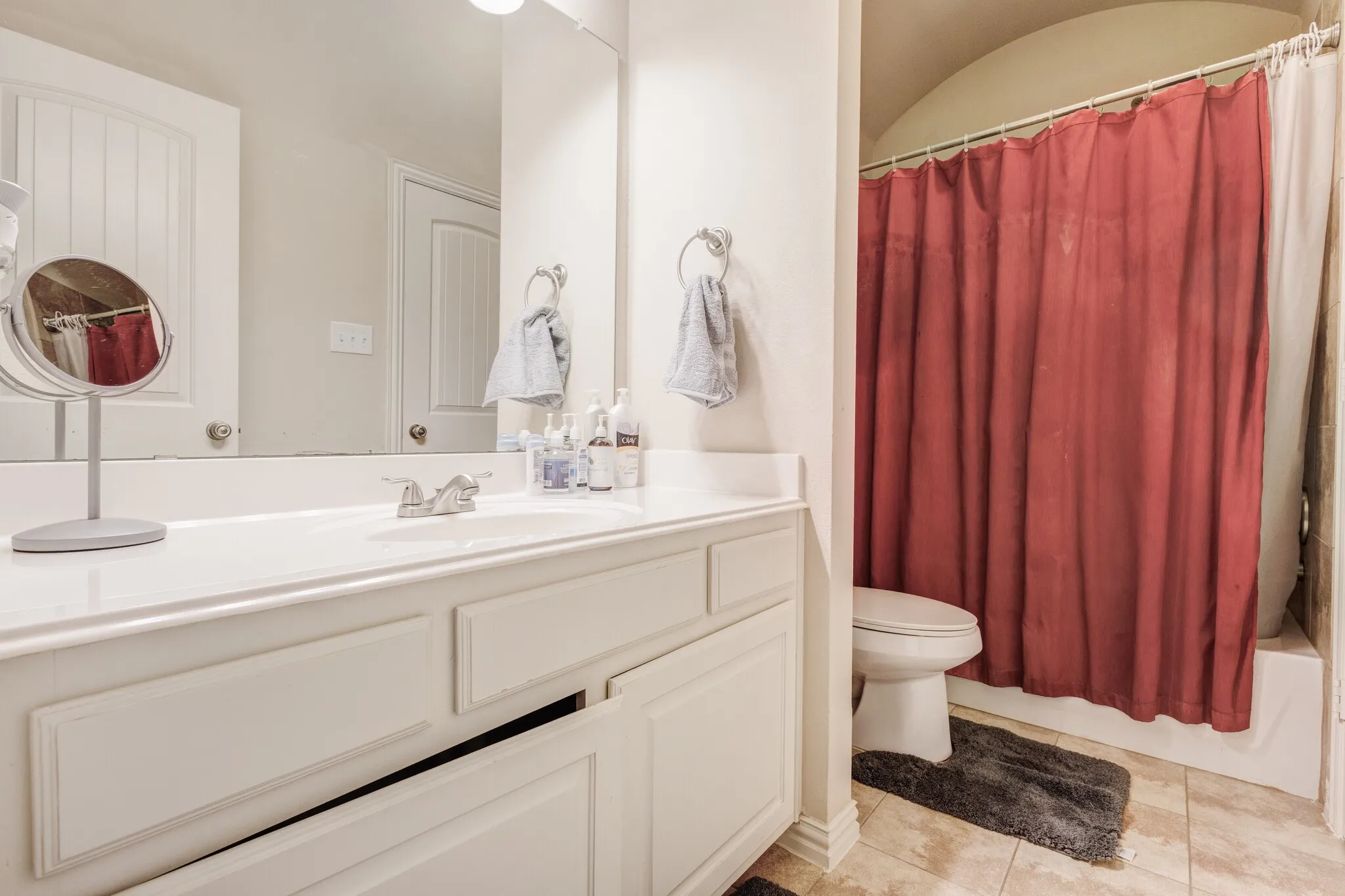 White vanity with integrated sink, chrome faucet, and panel-front cabinetry