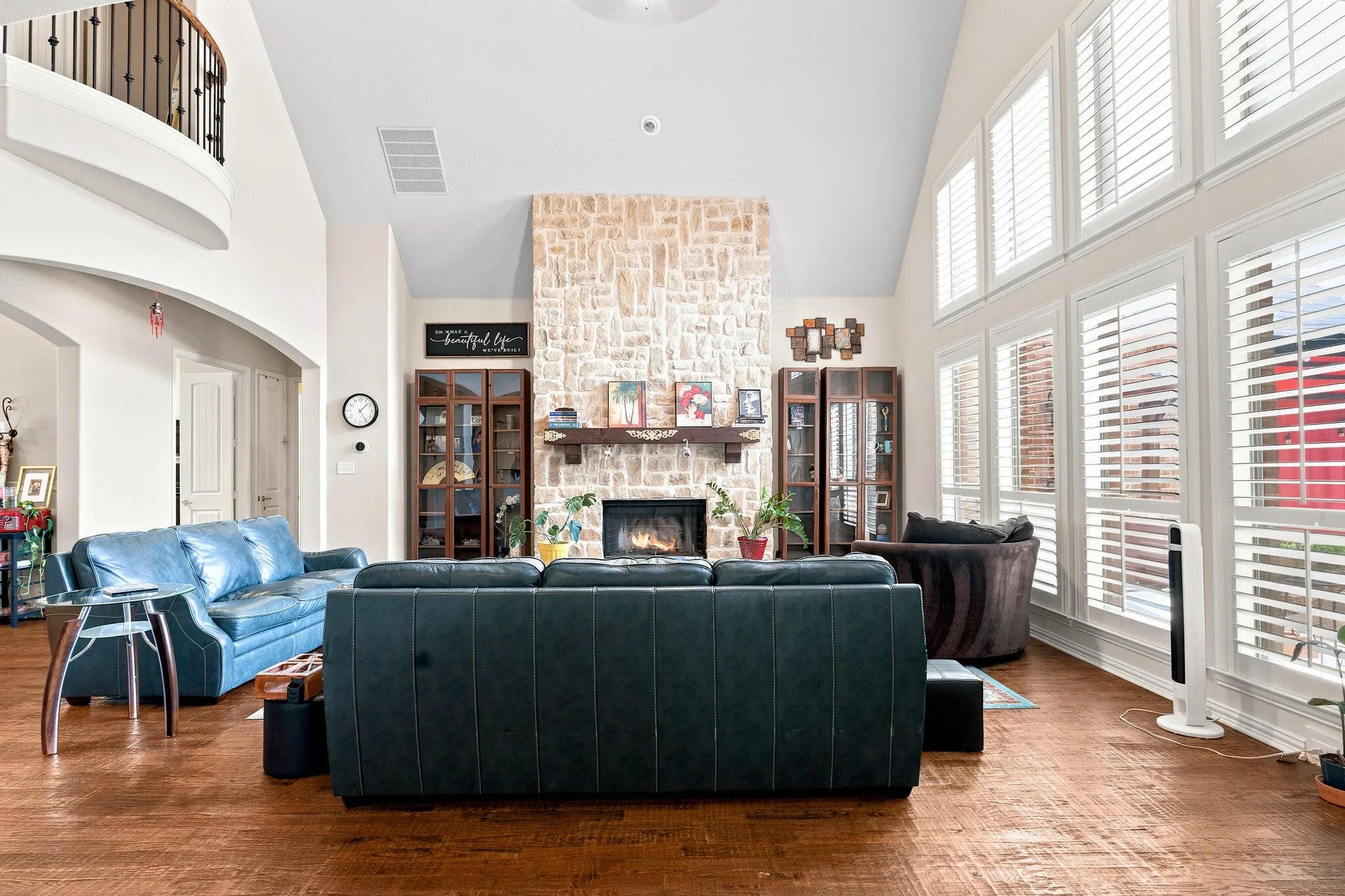 Vaulted ceiling with a stone-clad fireplace and wood mantel