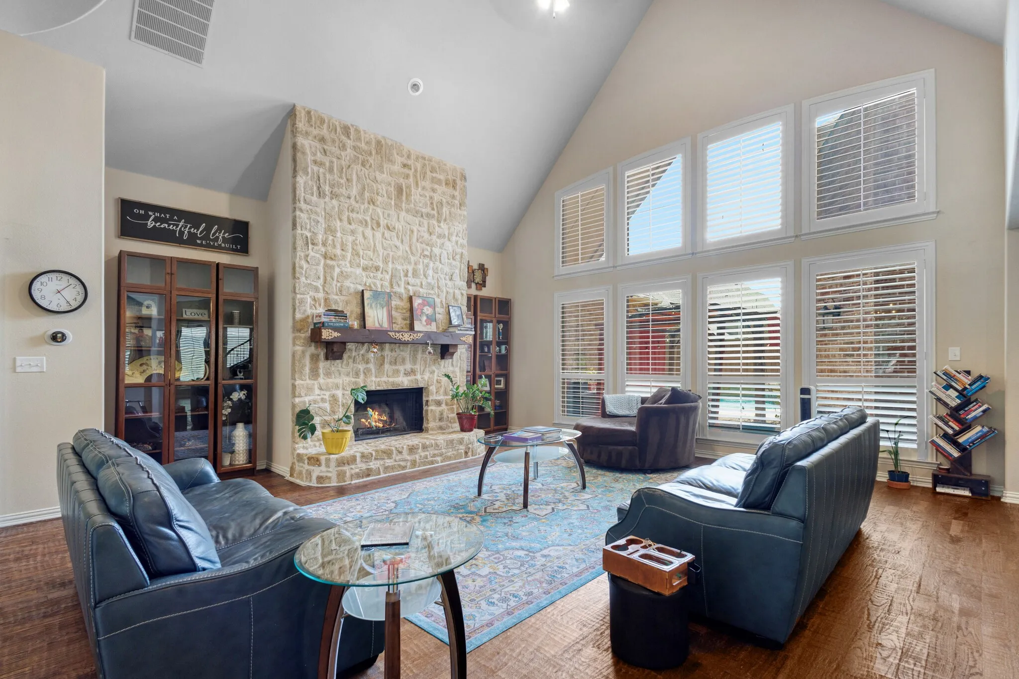 Vaulted ceiling with a stone-clad fireplace and wood mantel