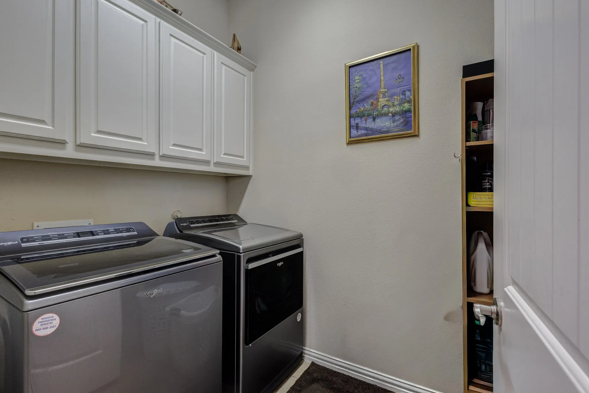 White shaker-style upper cabinetry, built-in shelving, and light-toned wall paint