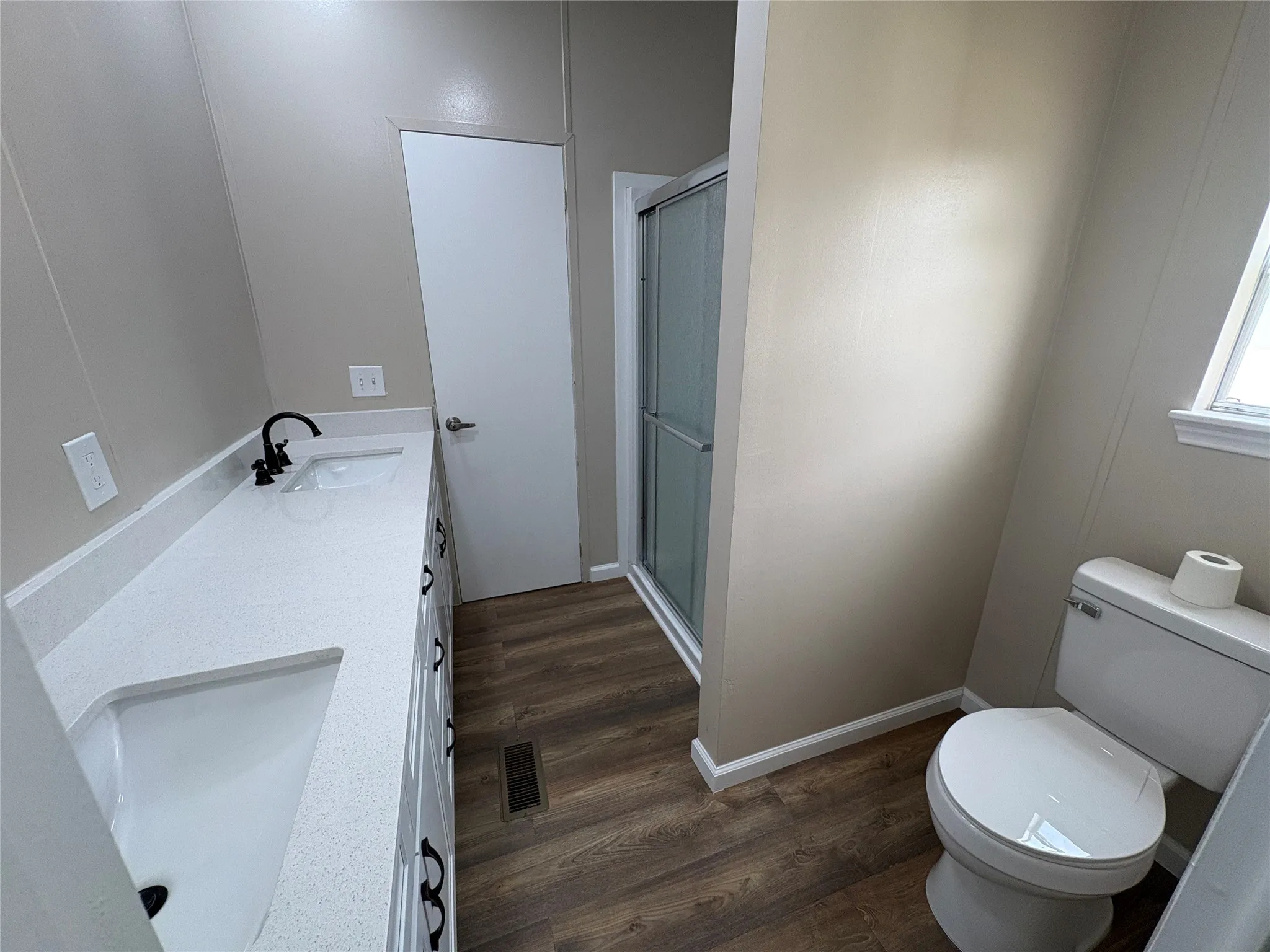 Primary bathroom dual vanity with white countertops, undermount sinks, and matte black fixtures