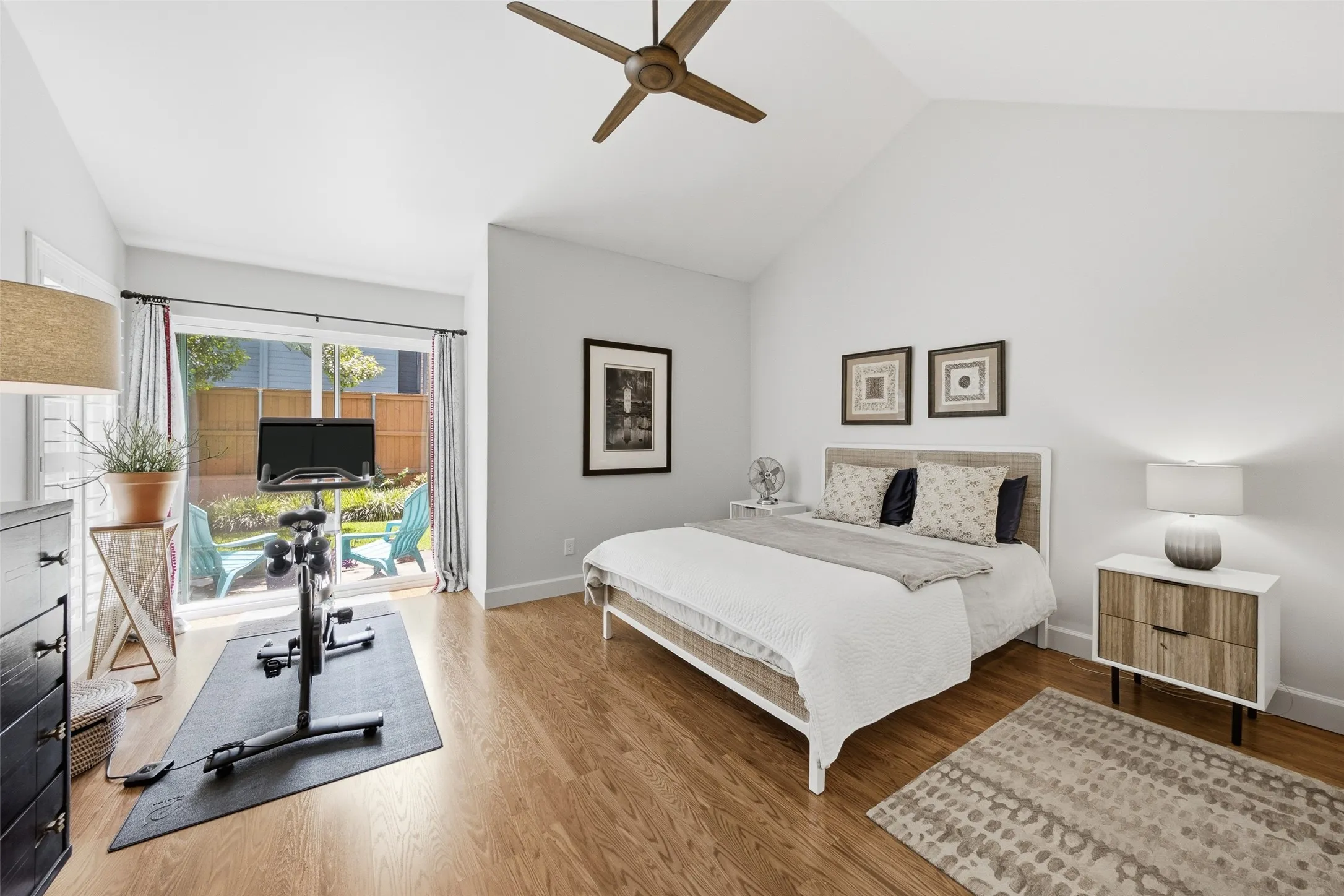 The primary suite on the main floor offers vaulted ceilings, hardwood floors, and a sliding glass door that opens directly to the back patio — an easy indoor-outdoor connection to start or end the day.