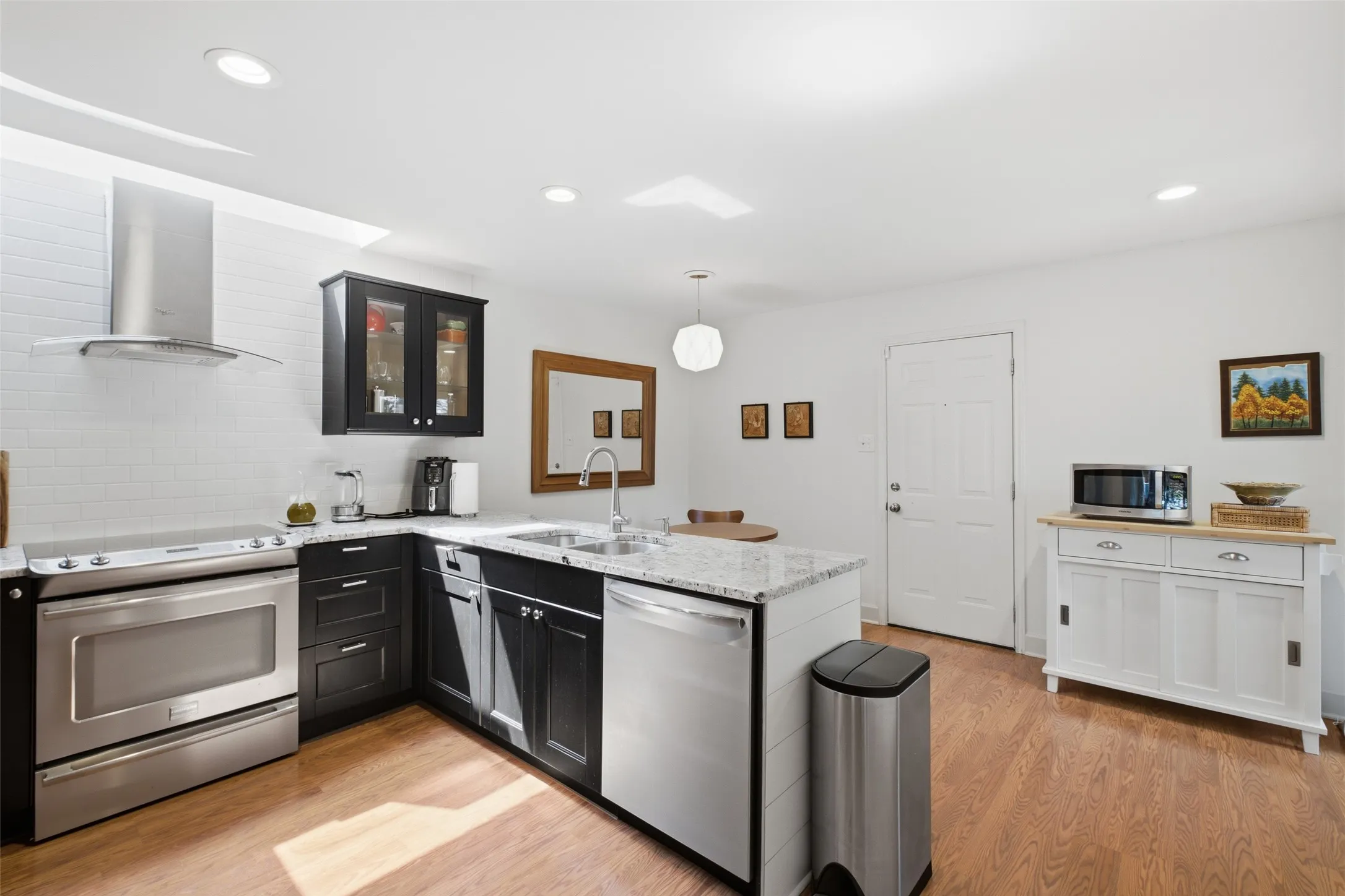 The kitchen opens toward the dining area, so you're never cut off from the rest of the home while cooking. Hardwood floors, recessed lighting, and clean cabinetry throughout.