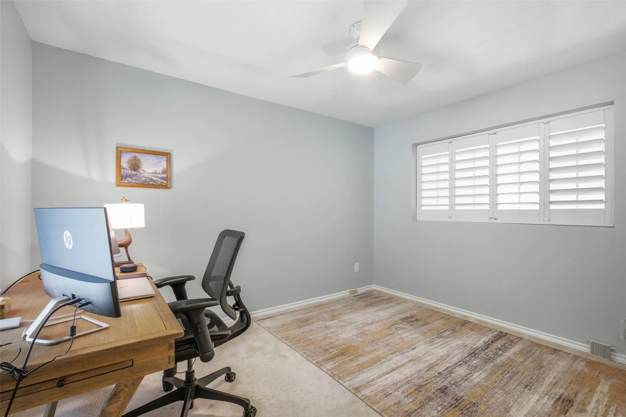 Flexible space upstairs: a third bedroom or office with plantation shutters, carpet, ceiling fan, and a private bath connection. Great bones for however you'd use it.