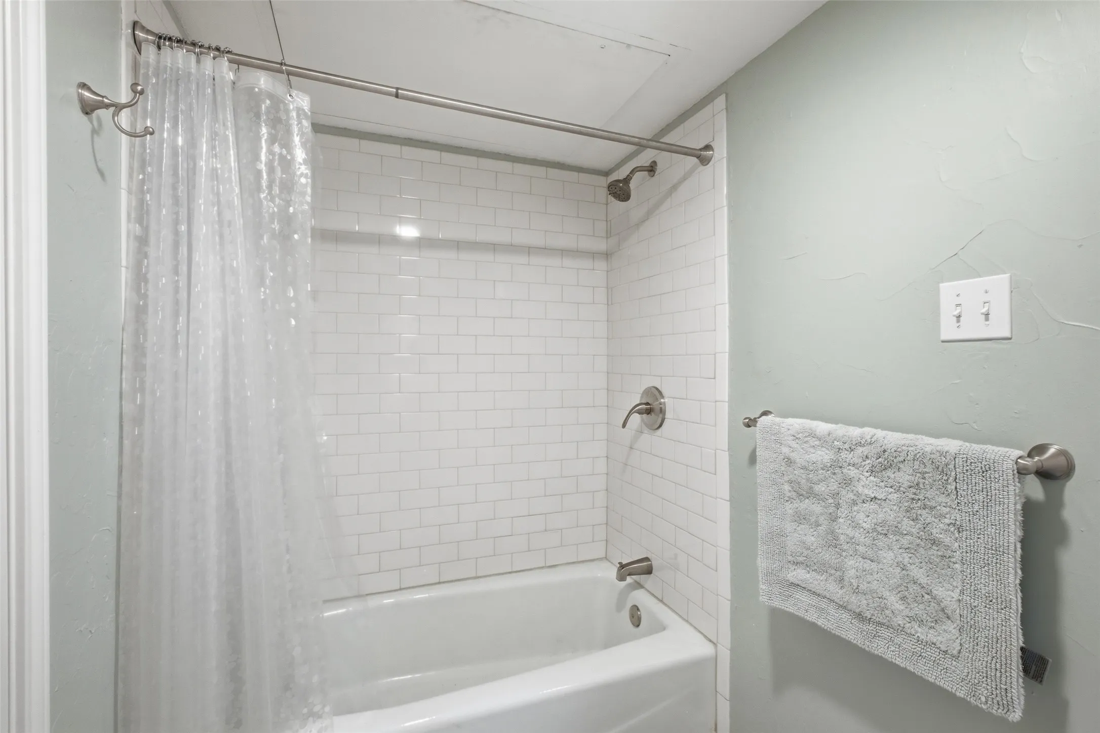 Clean white subway tile, brushed nickel fixtures, and a tub-and-shower combo — this upstairs bath is well-maintained and ready to go.
