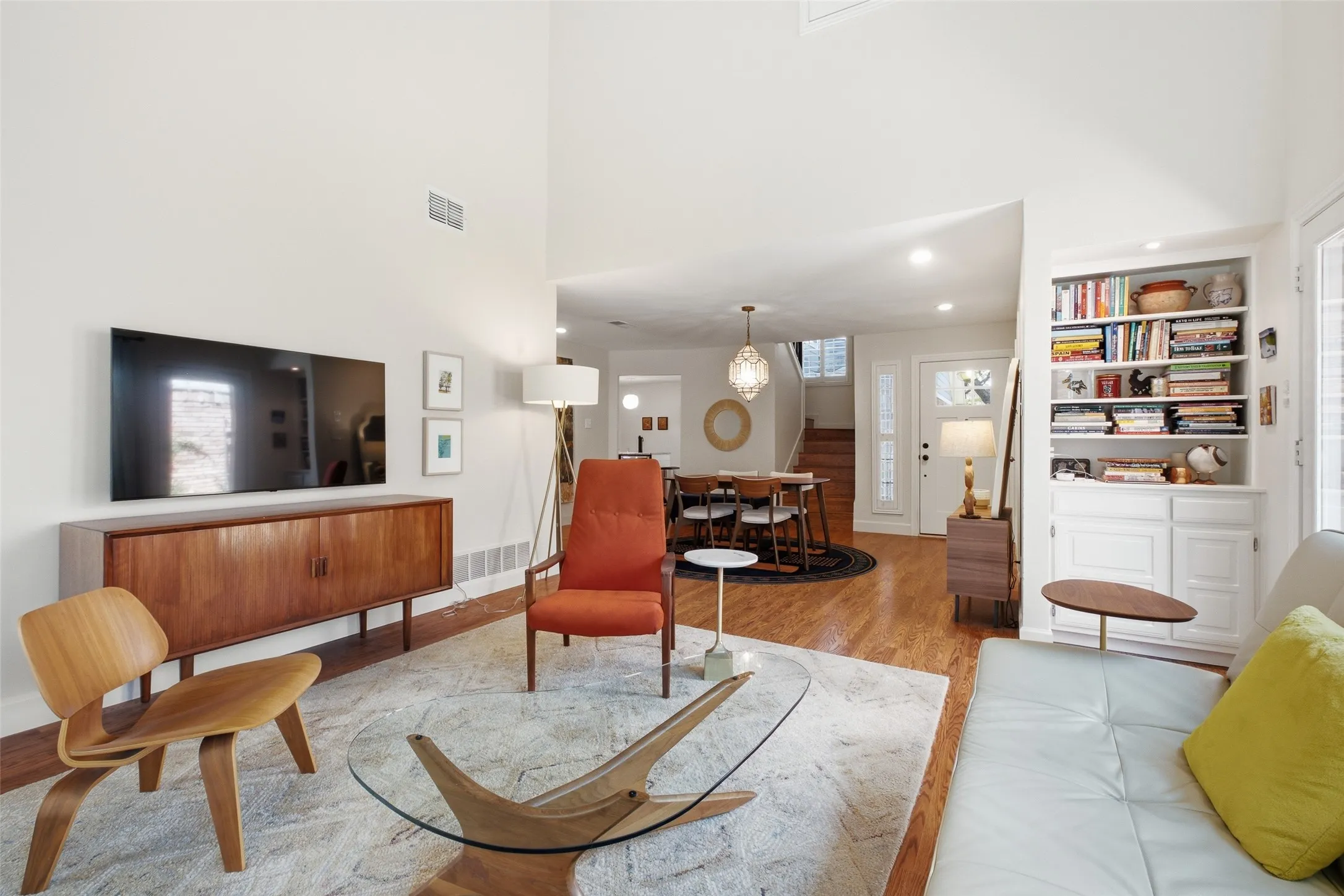 From the living room, you can see straight through to the dining area and front entry — a wide, open floor plan that feels connected without being cramped. Built-in shelving adds character and storage.