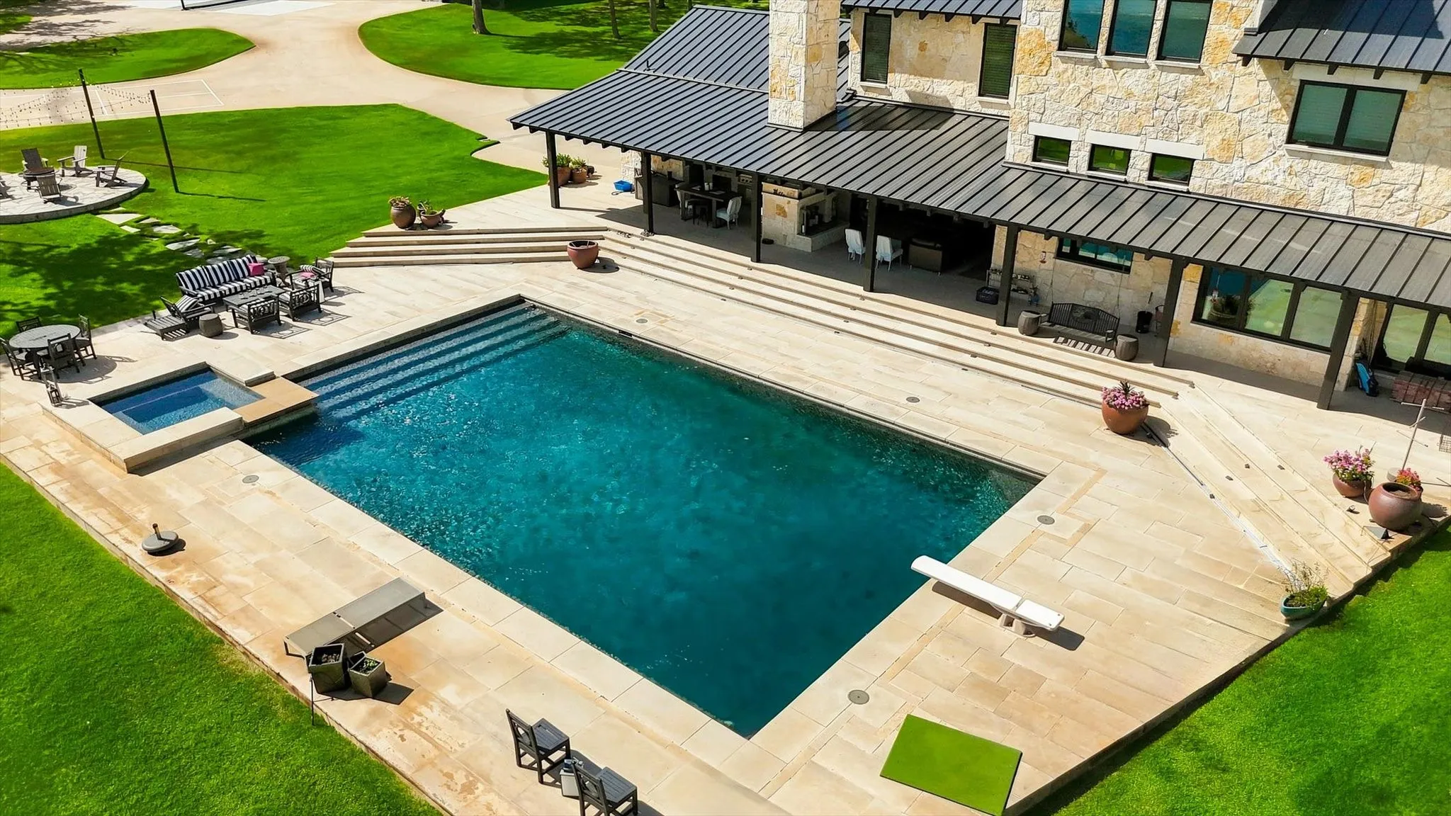 Expansive rectangular swimming pool with integrated spa and diving board