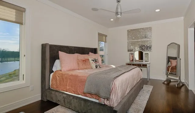 Hardwood flooring, crown molding, recessed lighting, ceiling fan, and large windows