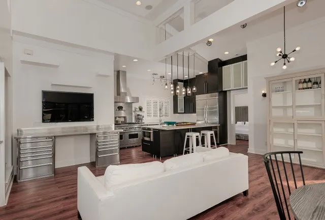 Vaulted ceiling with exposed beams, wood-finish flooring, recessed lighting, and a kitchen island with pendant lighting