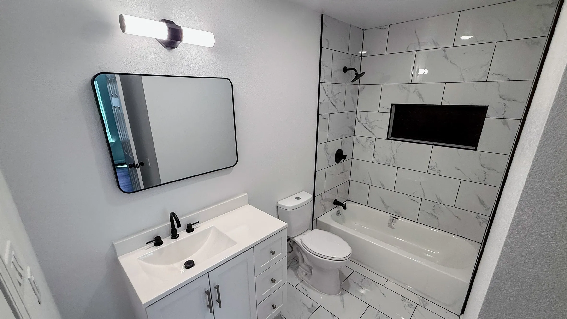 White vanity with integrated sink and matte black faucet