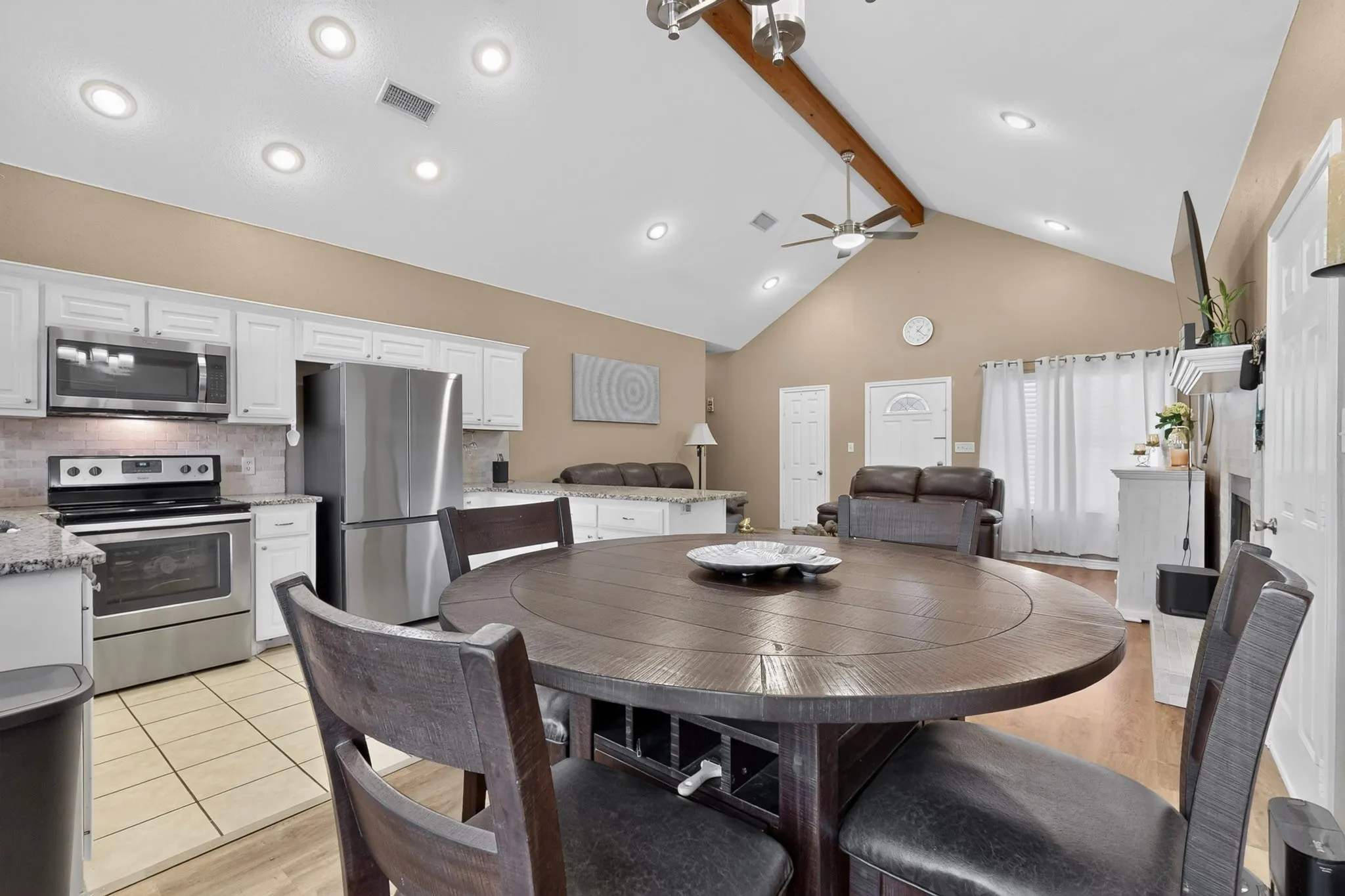 Vaulted ceiling with exposed wood beam, recessed lighting, and a ceiling fan
