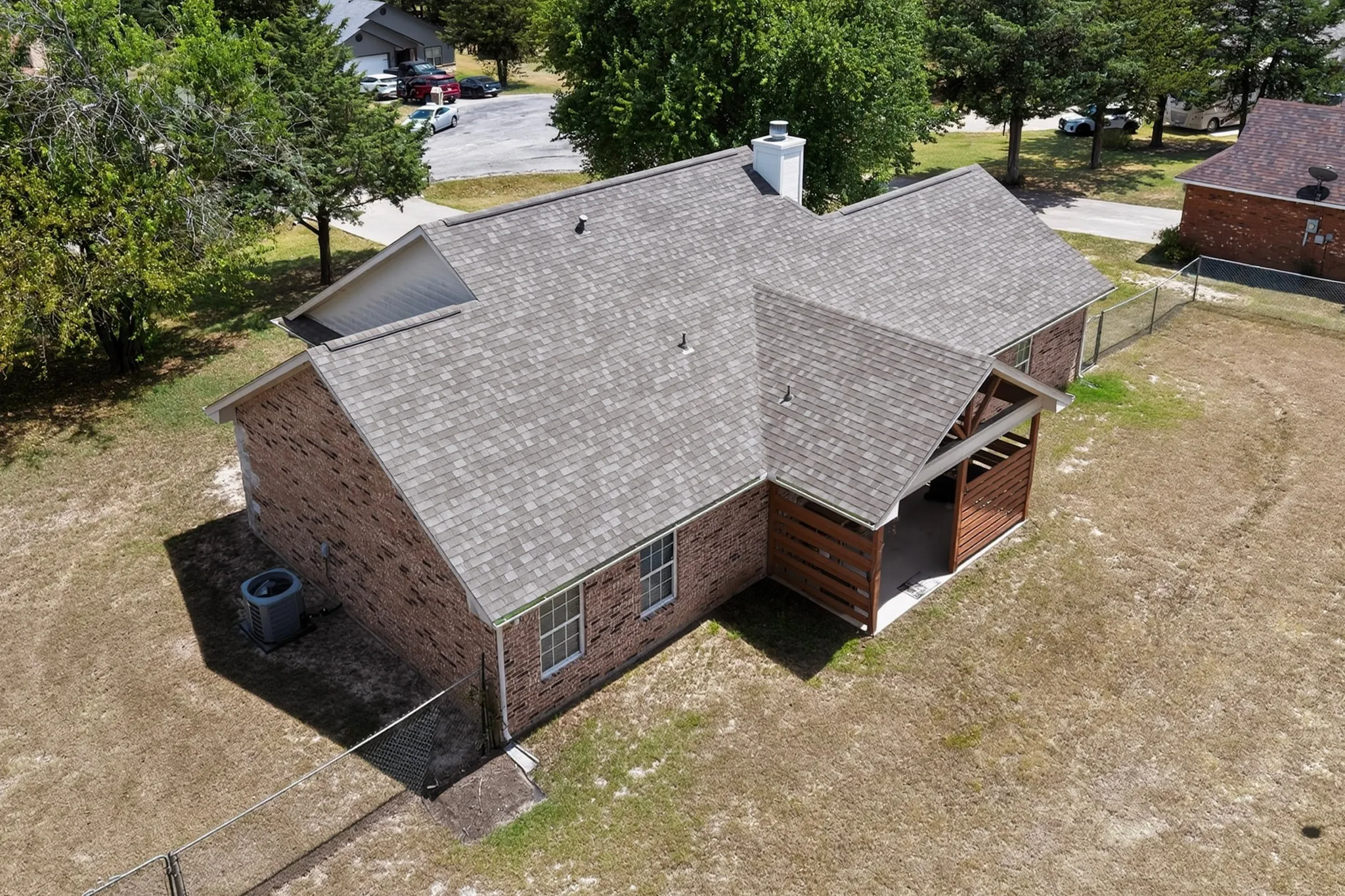 Brick exterior with an attached covered patio featuring wood-finish walls