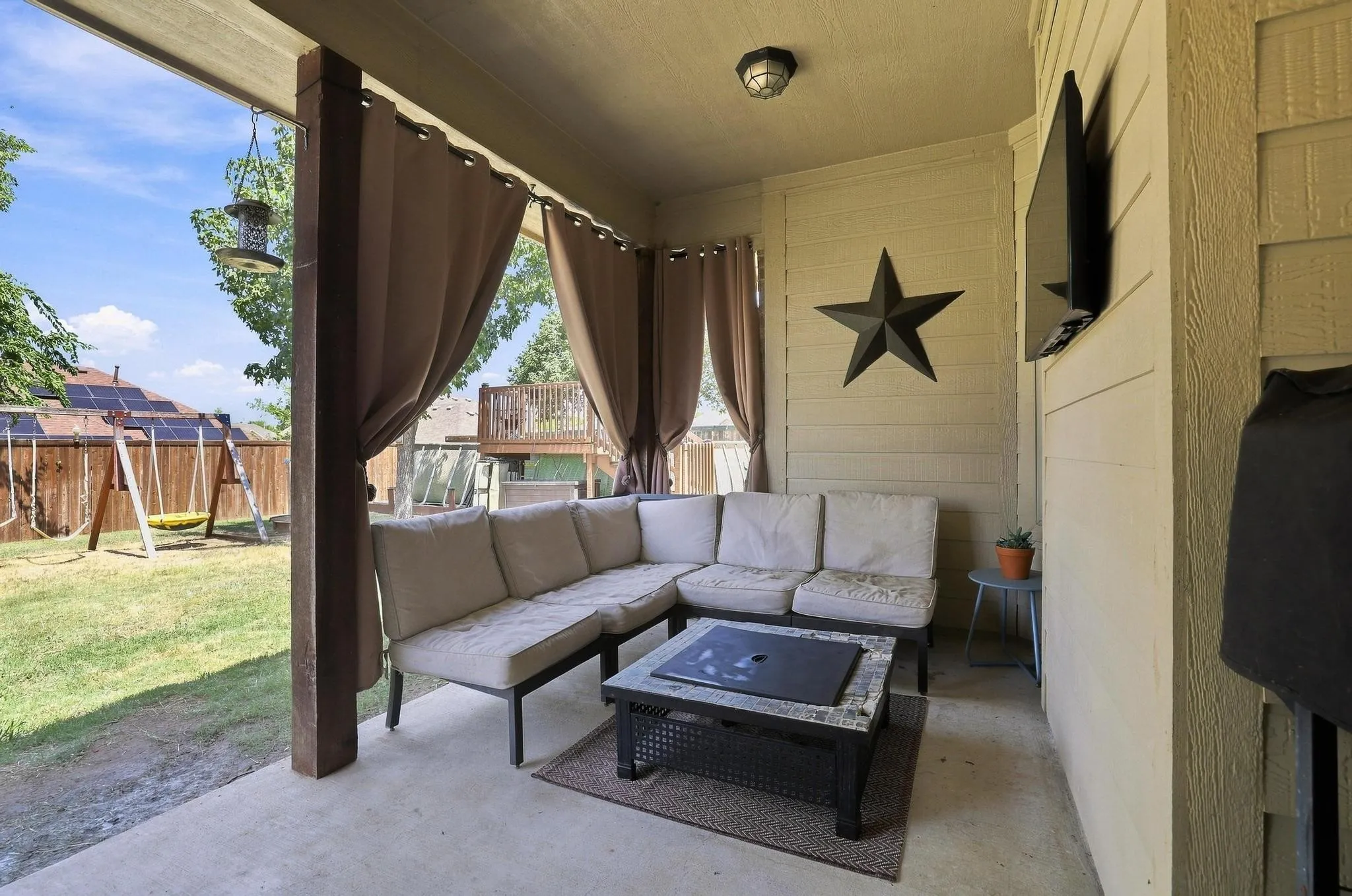 Covered patio with a concrete surface and wood-clad support posts
