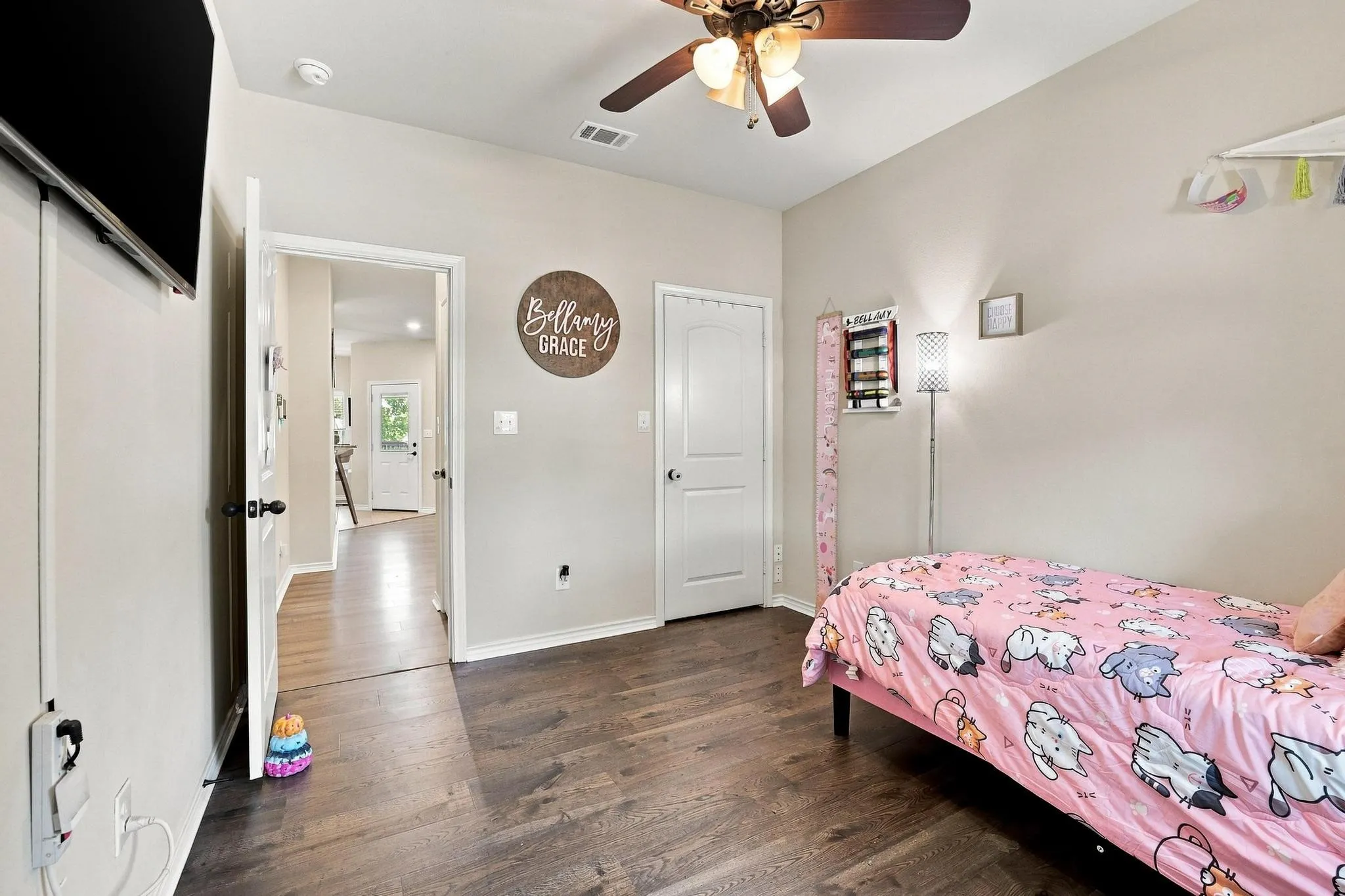 Wood-finish flooring throughout, ceiling fan with integrated lighting, and neutral wall tones