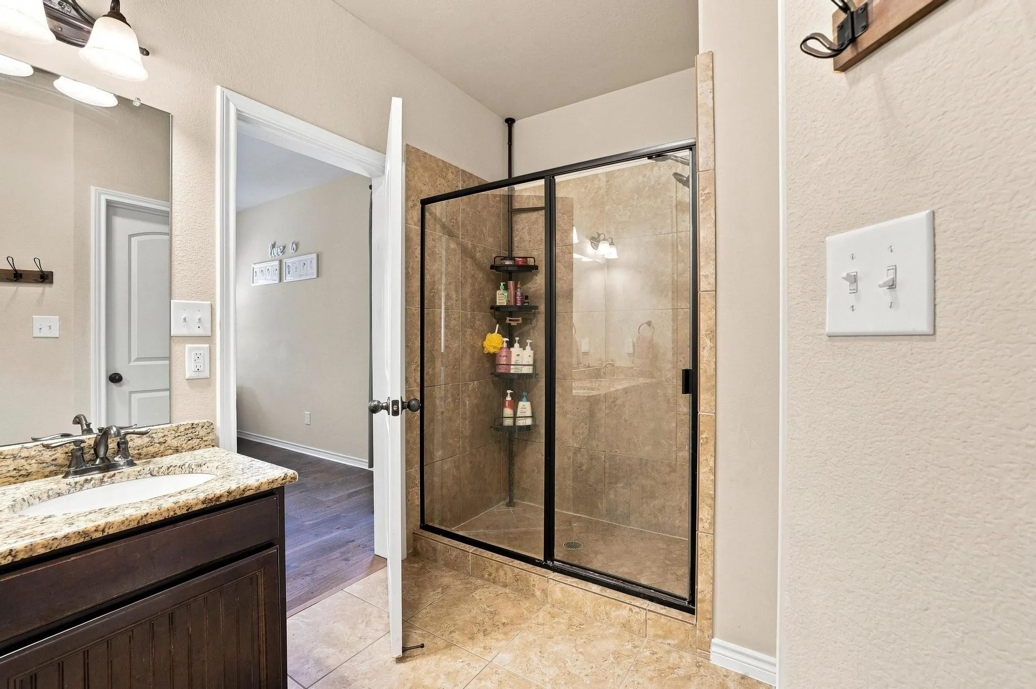 Walk-in shower with clear glass enclosure and tile surround