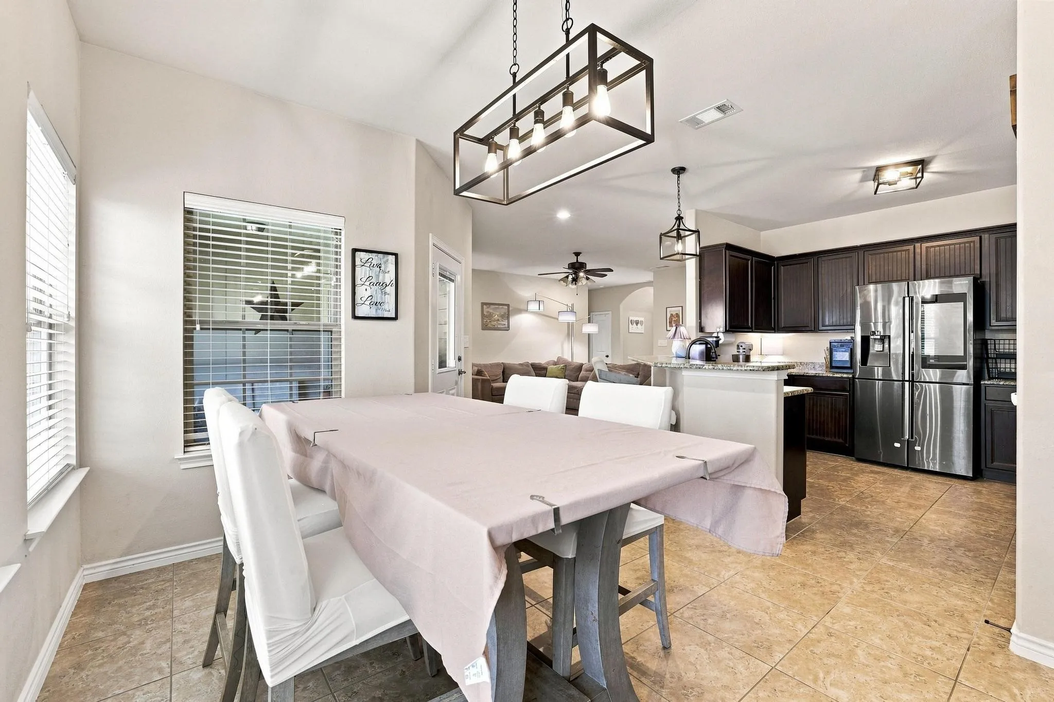 Dining area with tile flooring and a linear pendant light fixture