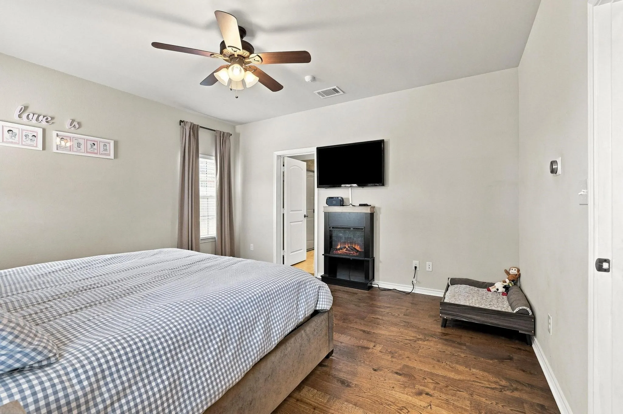 Wood-finish flooring, ceiling fan, and window with blinds
