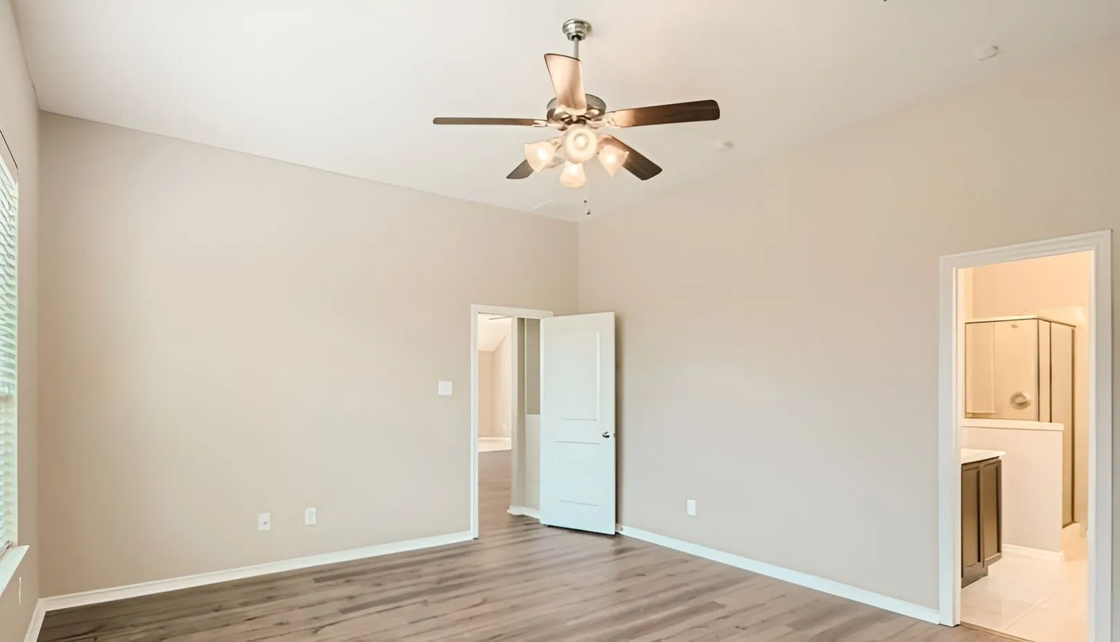 Vaulted ceiling with a ceiling fan, wood-finish flooring, and a window with blinds