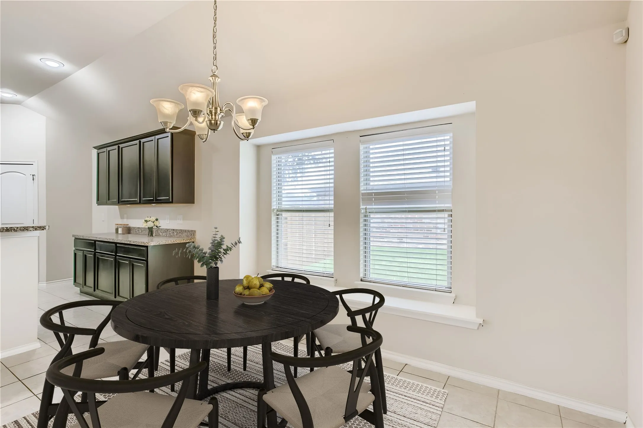 Vaulted ceiling with a chandelier, two large windows, built-in cabinetry with a countertop, and tile flooring