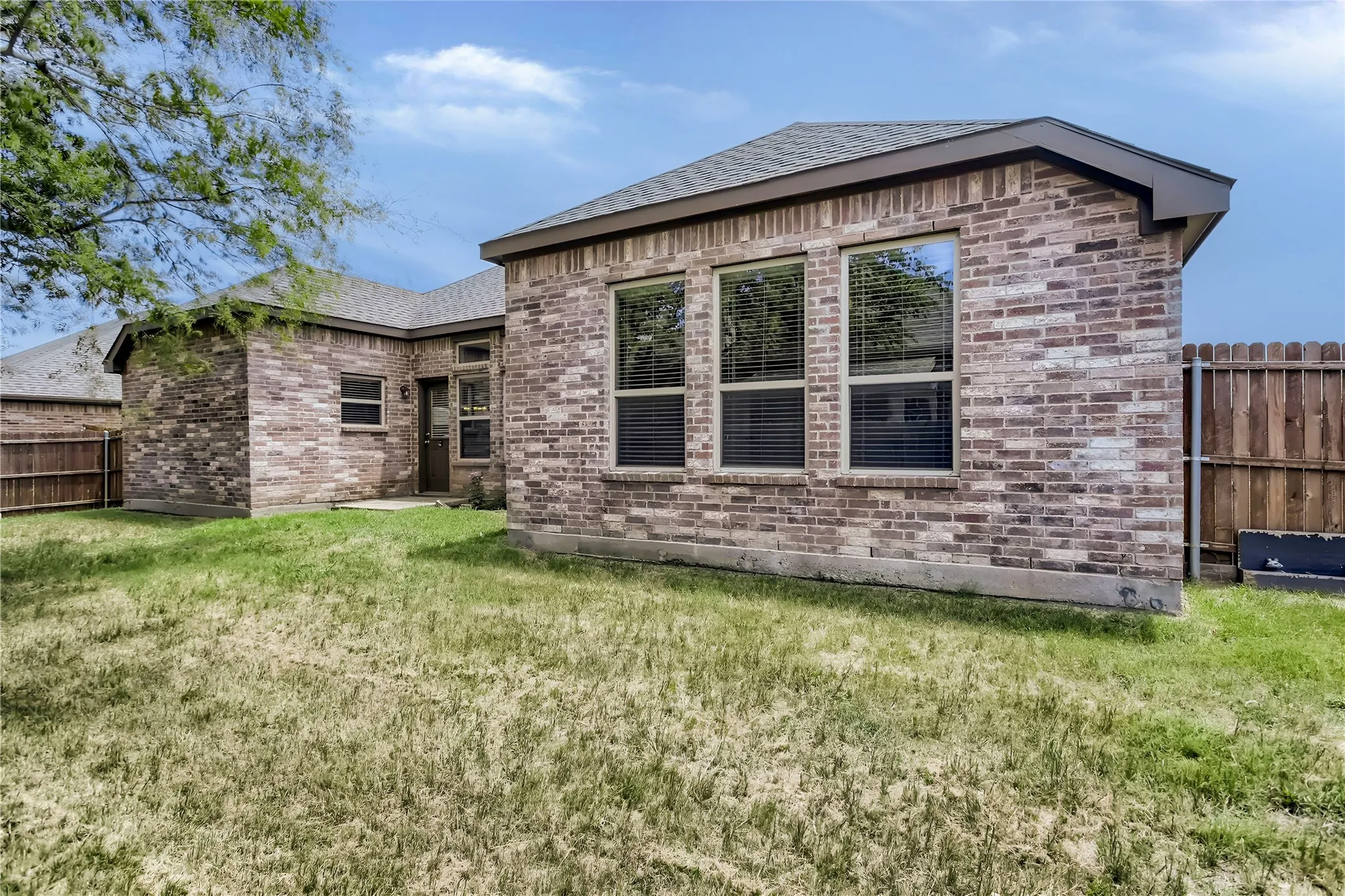 Brick exterior with a gabled roof and multiple windows