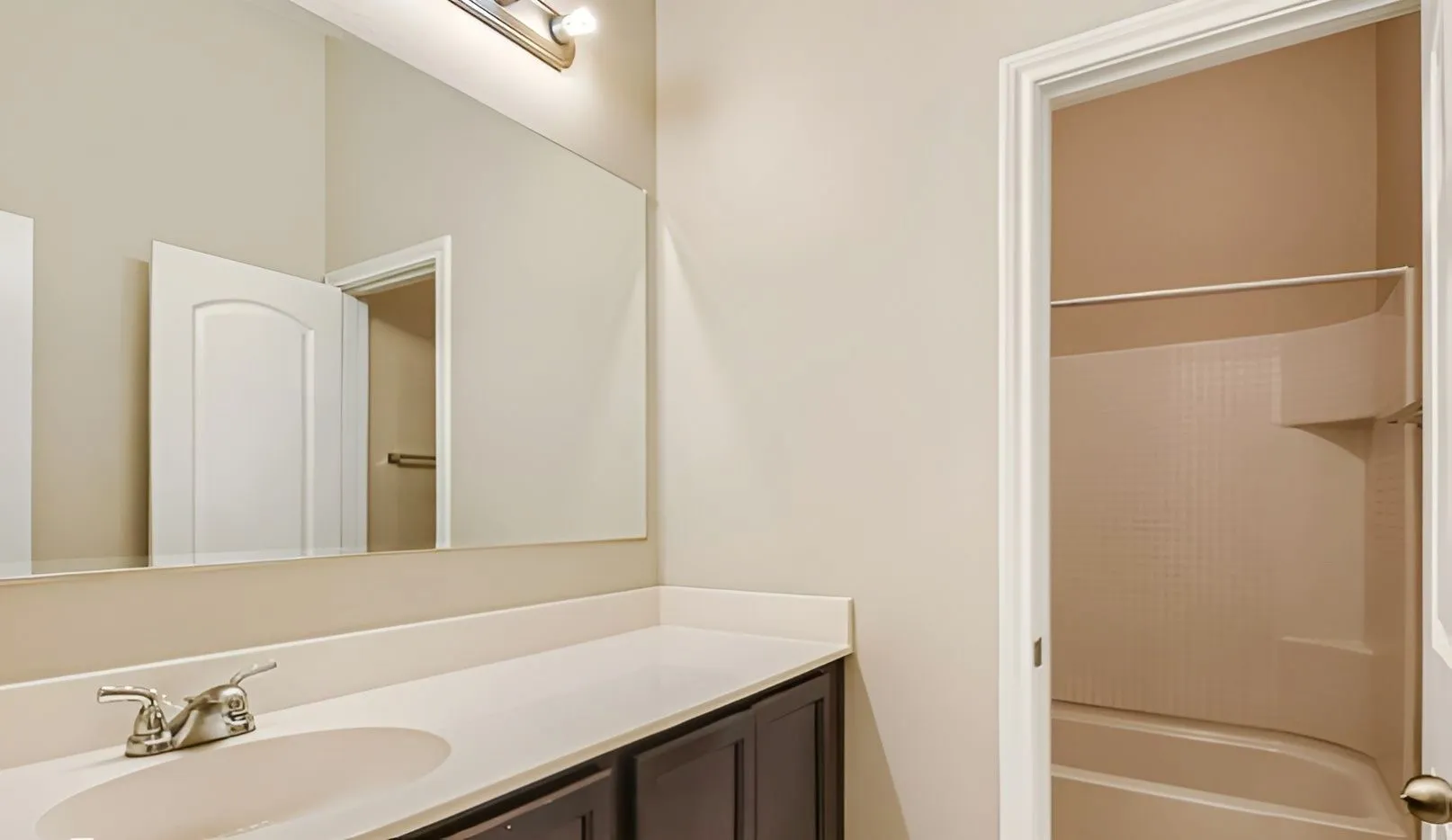 Vanity with a single basin sink, brushed nickel faucet, and white countertop