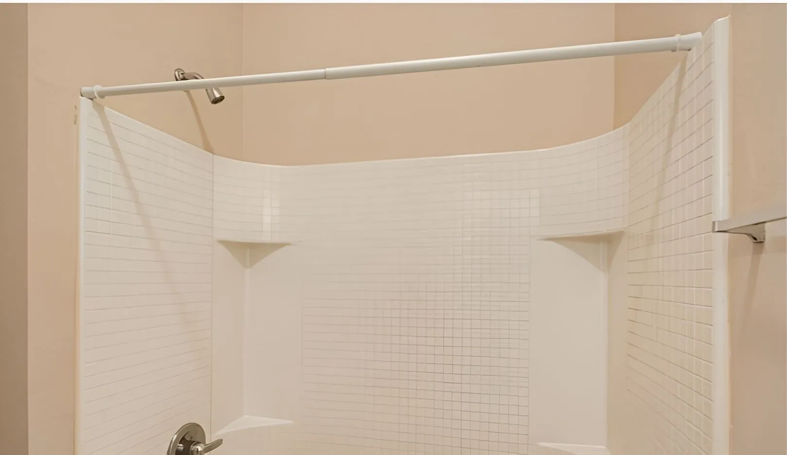 White shower surround with integrated shelving and a brushed nickel showerhead