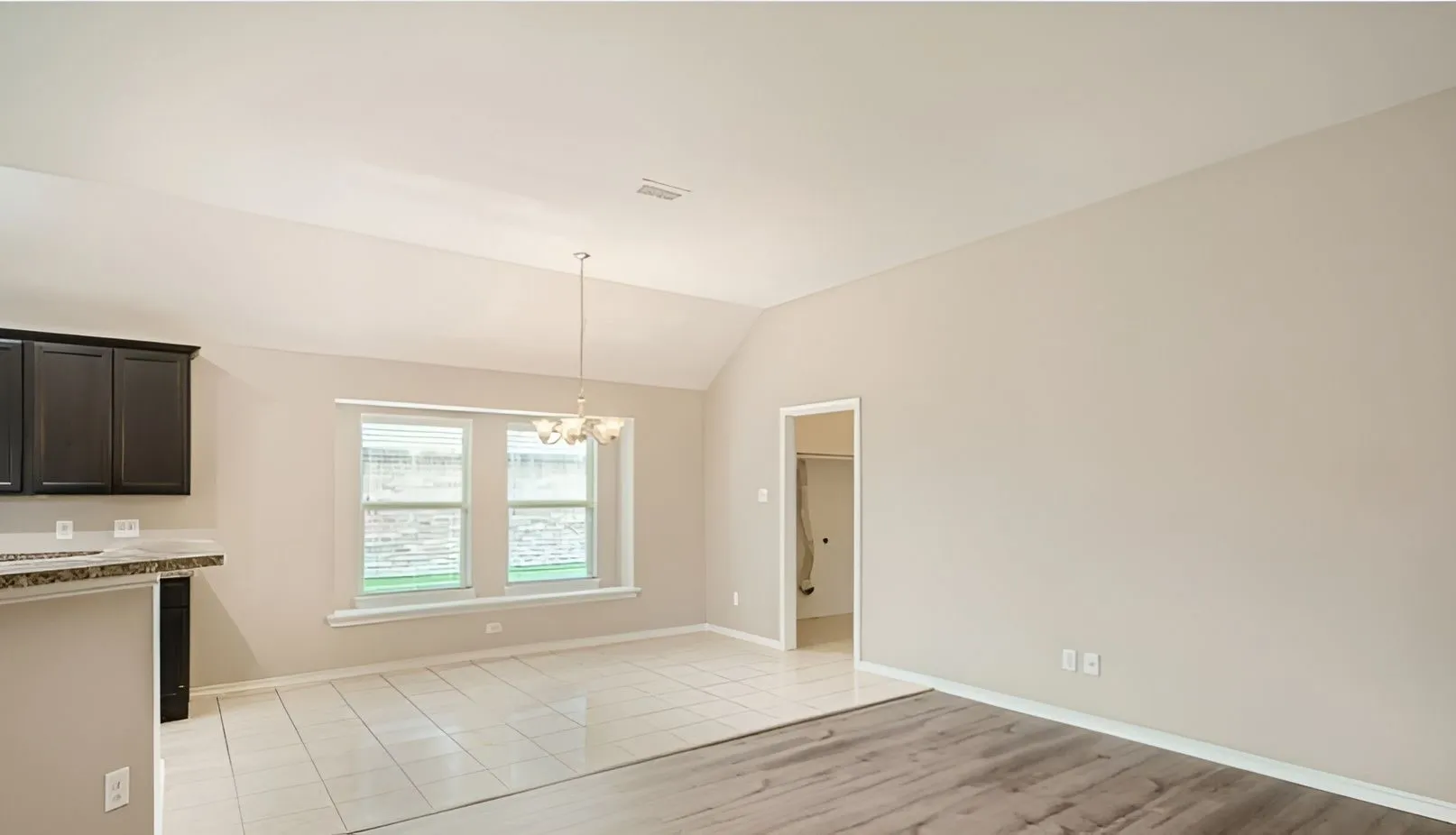 Vaulted ceiling, recessed lighting, tile flooring, wood-finish flooring, dark wood cabinetry