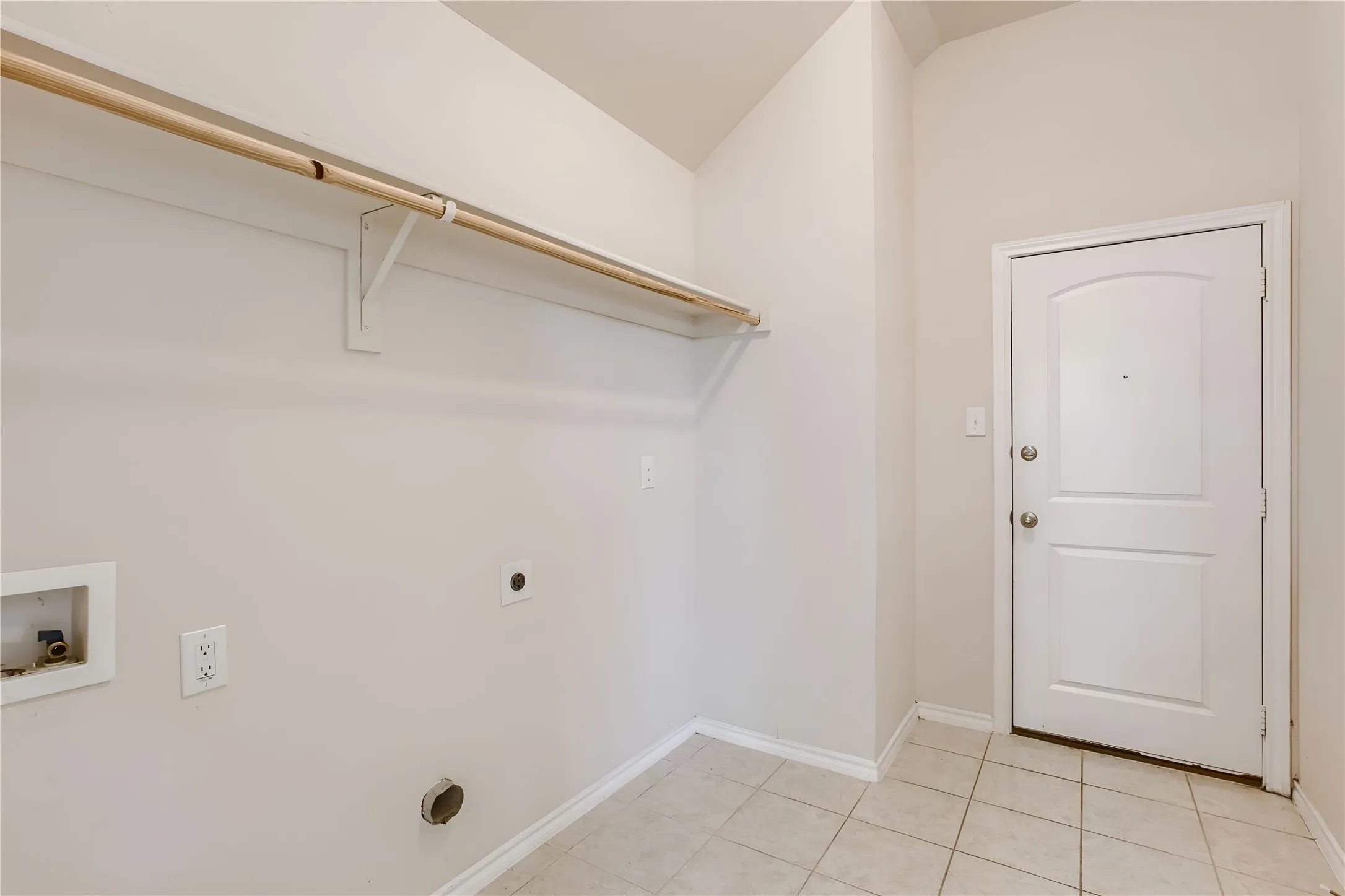Laundry area featuring a utility hookup, clothing rod, and tiled flooring