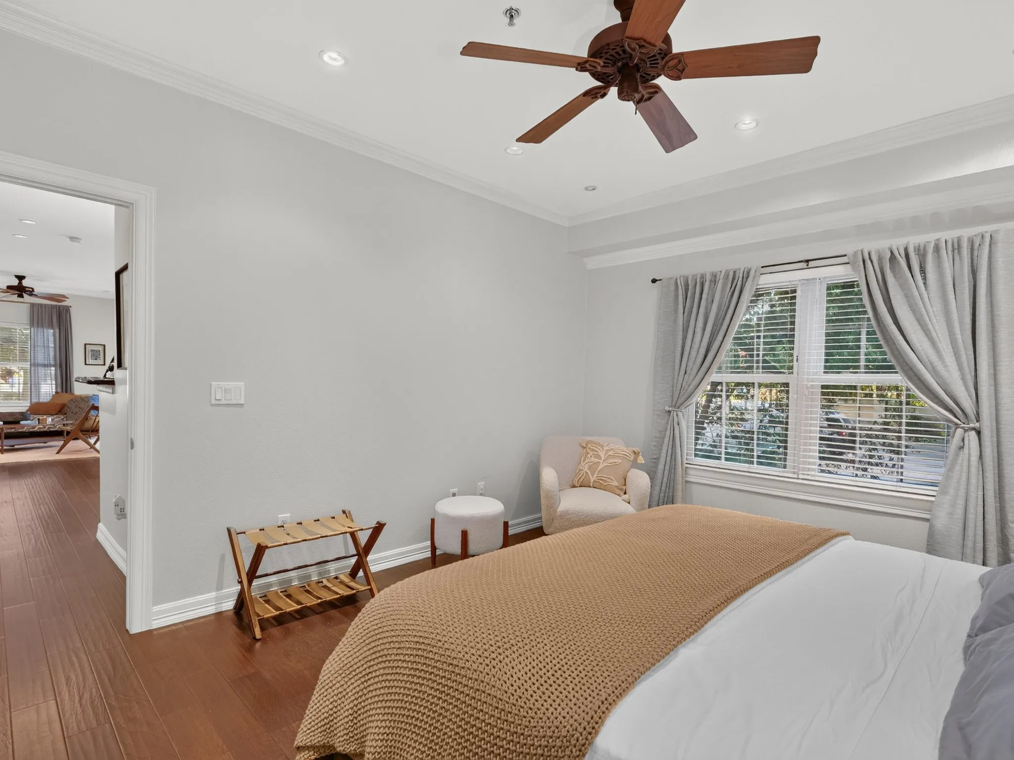 Hardwood-finish flooring, recessed lighting, crown molding, a ceiling fan, and a window with blinds