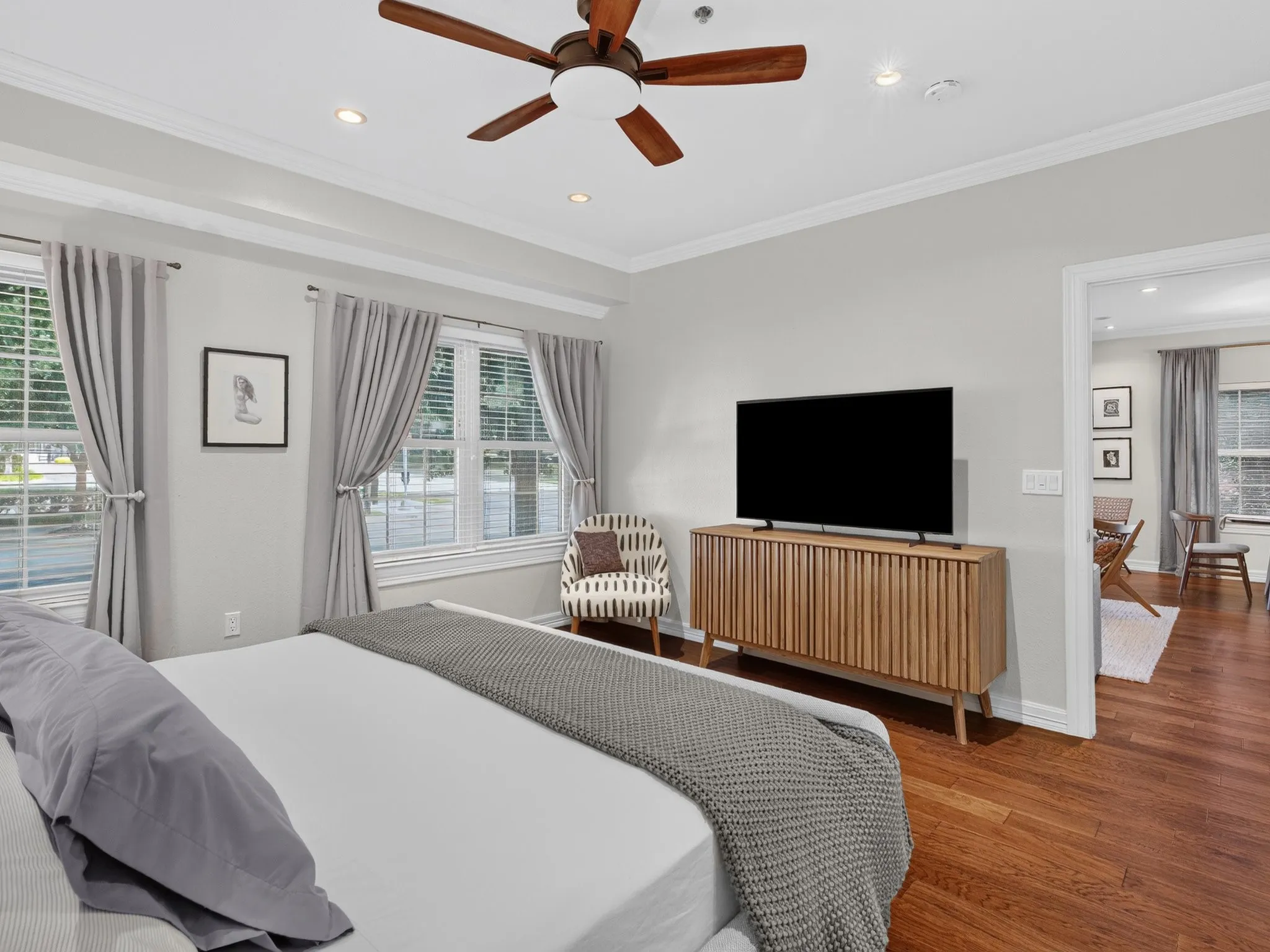 Hardwood-style flooring, ceiling fan, recessed lighting, crown molding, and double windows with blinds