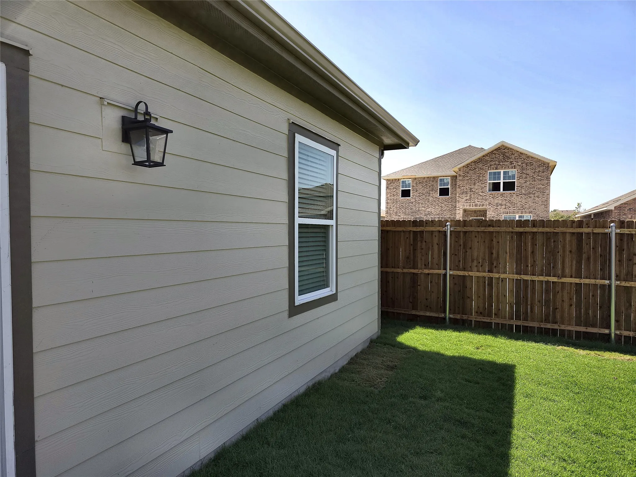 Beige horizontal siding exterior with white-framed window