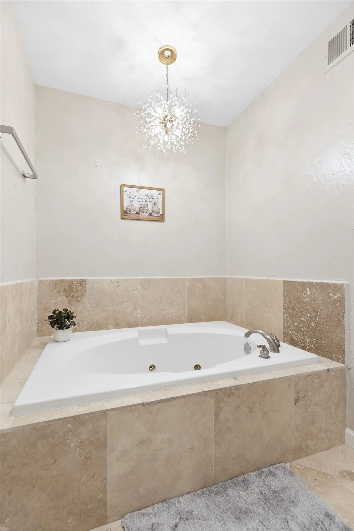 Built-in jetted tub with stone tile surround and deck