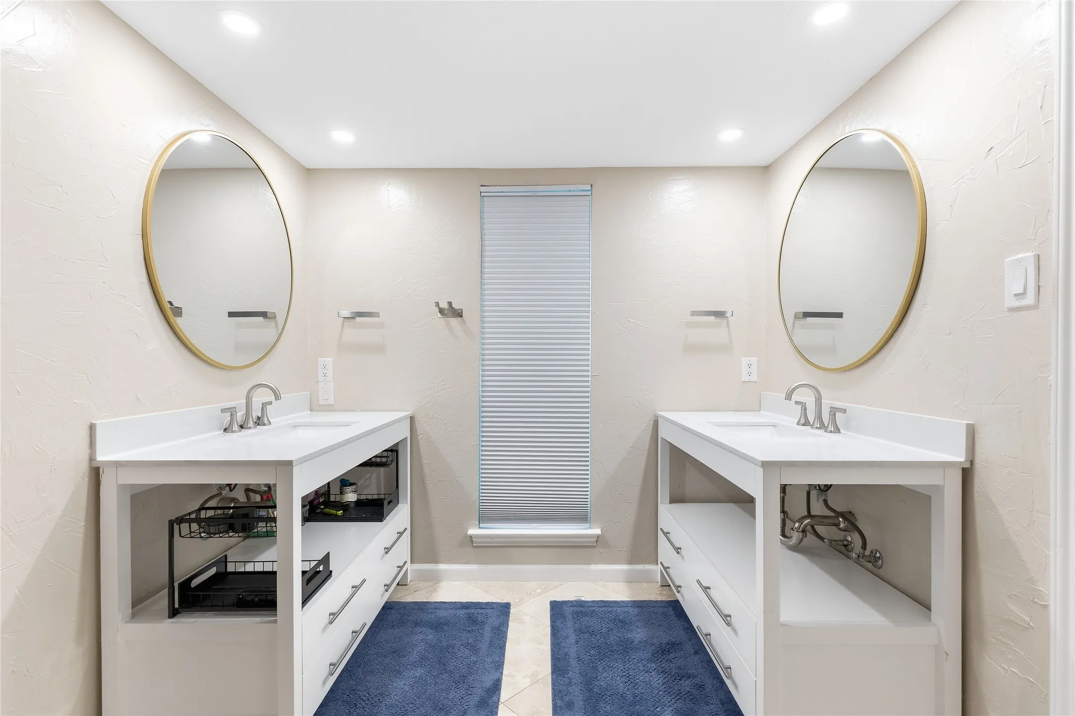 Dual vanities with white countertops, undermount sinks, and brushed nickel faucets