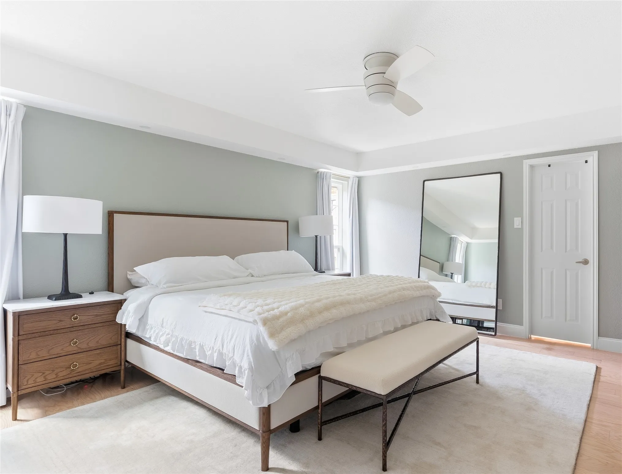 Hardwood flooring, tray ceiling, recessed lighting, and a ceiling fan with integrated lighting