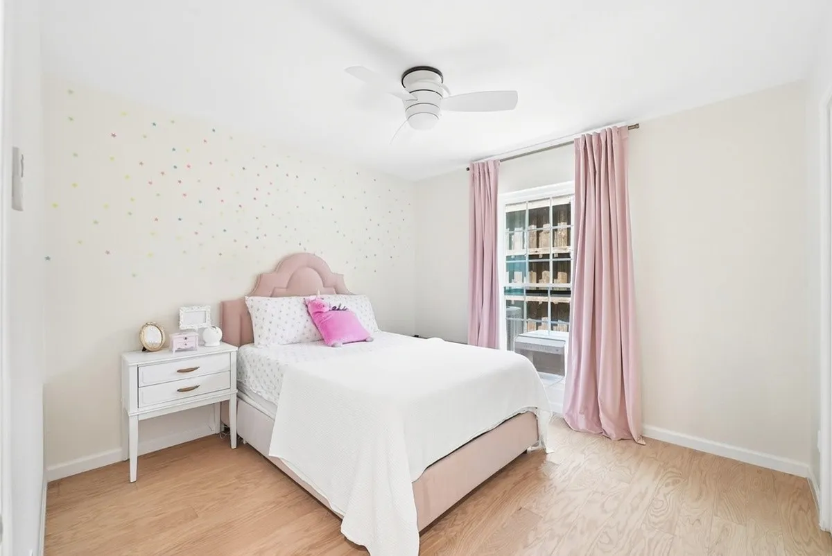 Wood-finish flooring, white walls, and a ceiling fan with integrated lighting
