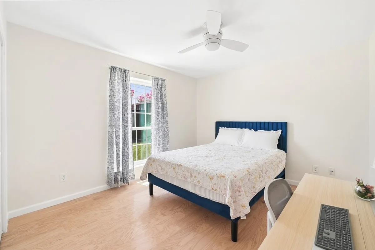Recessed window with natural light, ceiling fan with integrated lighting, light wood-finish flooring, and white painted walls