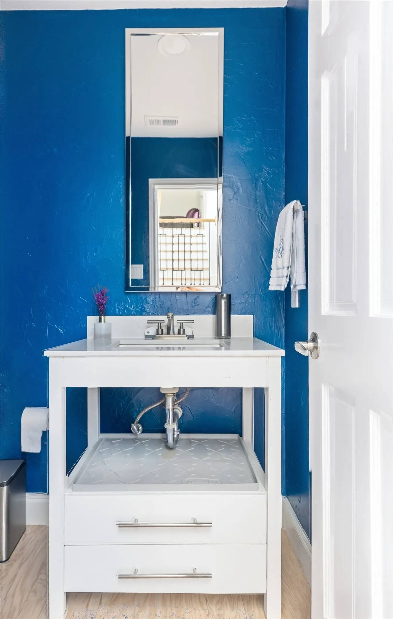 White vanity with dual drawers, integrated sink, and brushed nickel hardware