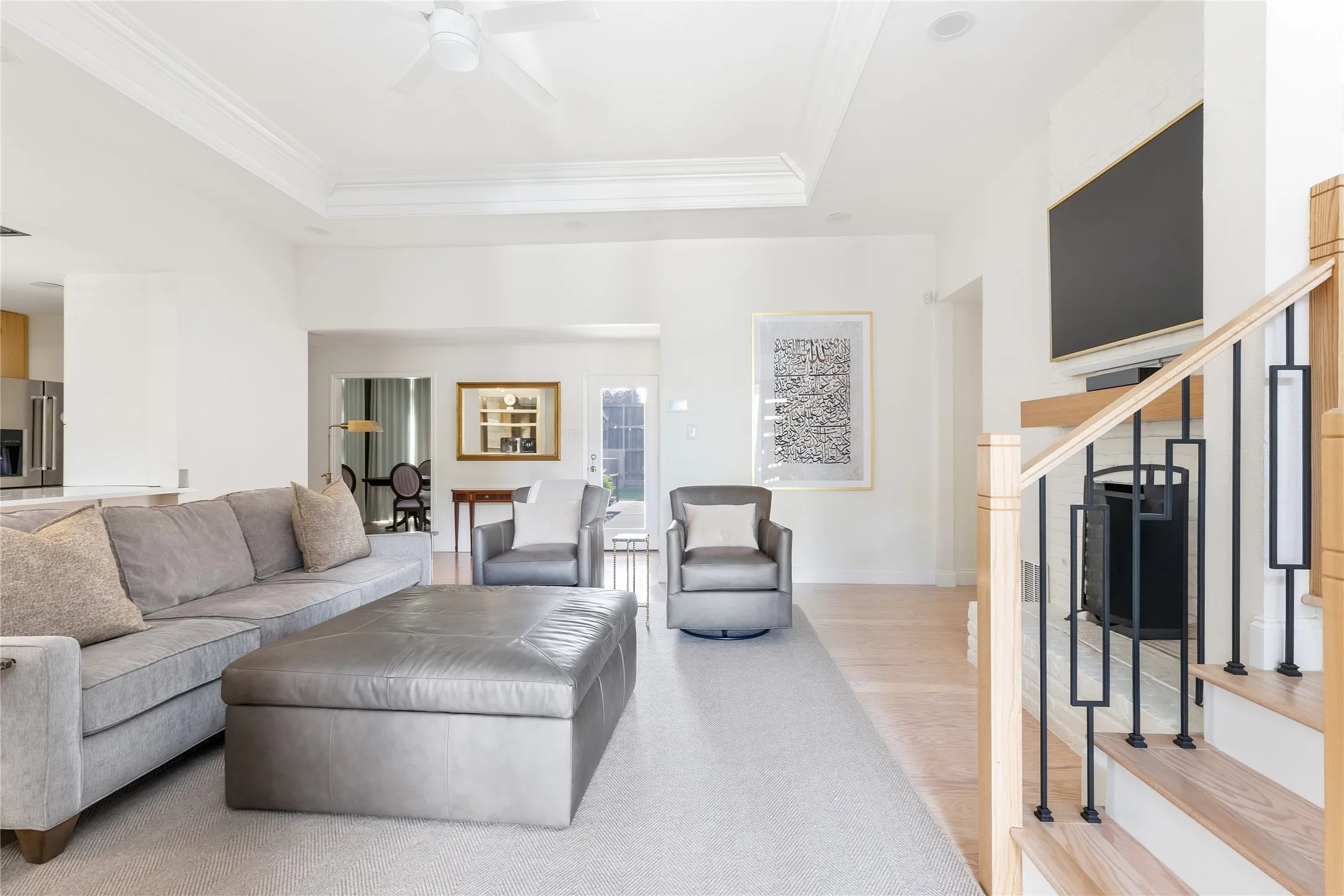 Recessed ceiling with a ceiling fan, hardwood flooring, and a contemporary fireplace