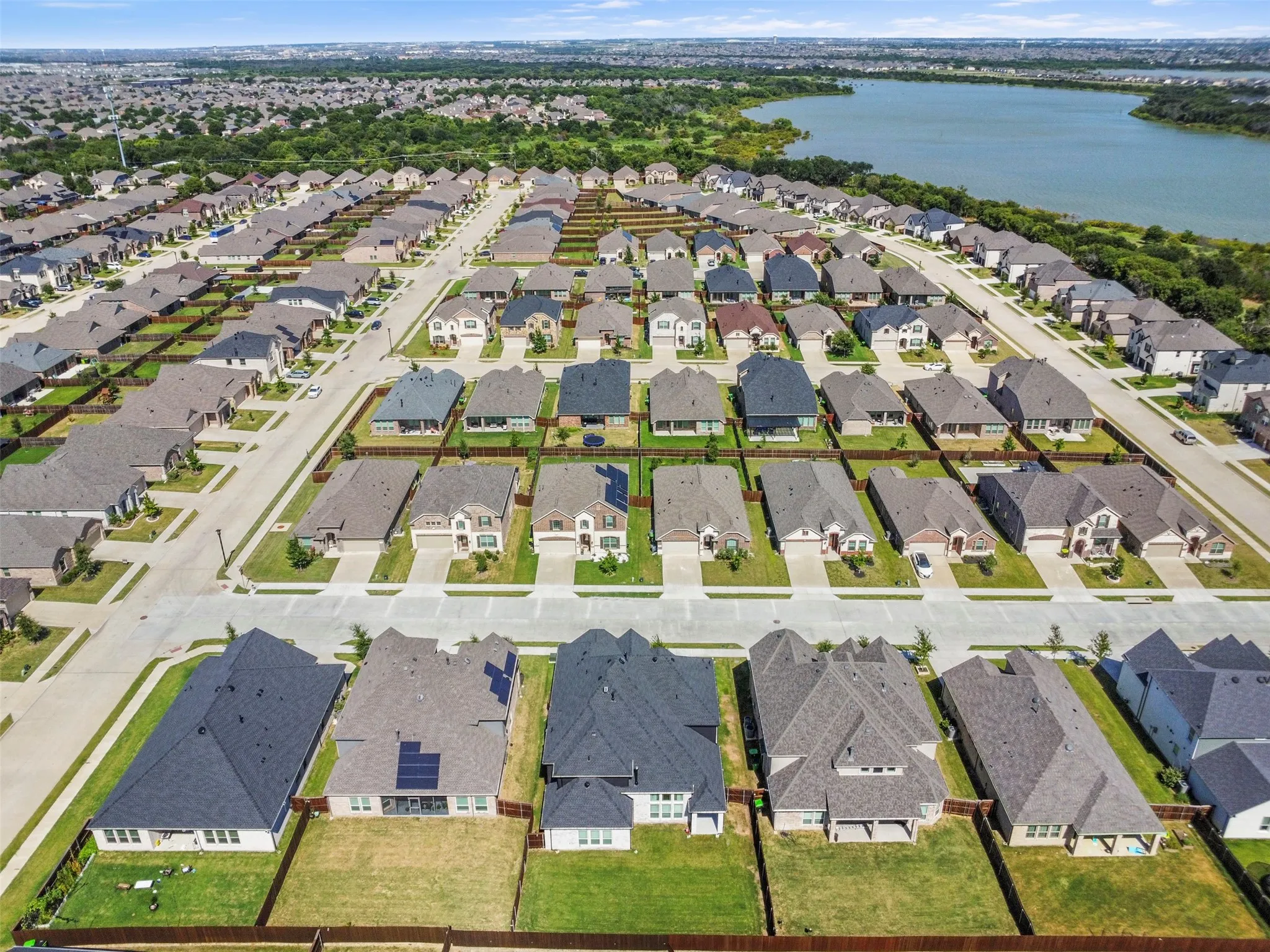 Residential development featuring a variety of single-family homes with pitched roofs, front-facing garages, and manicured lawns