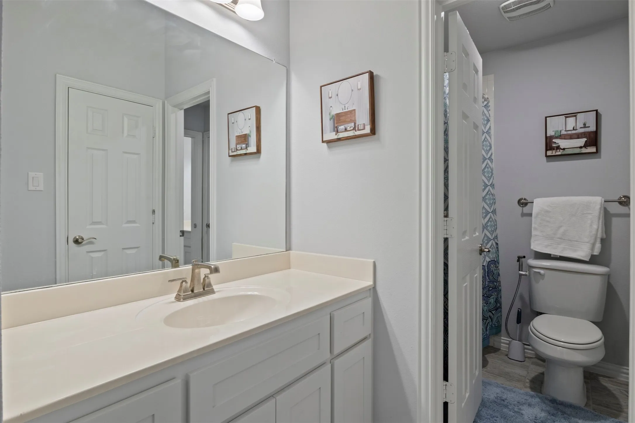 Built-in vanity with an integrated sink, brushed nickel faucet, and a large wall-mounted mirror